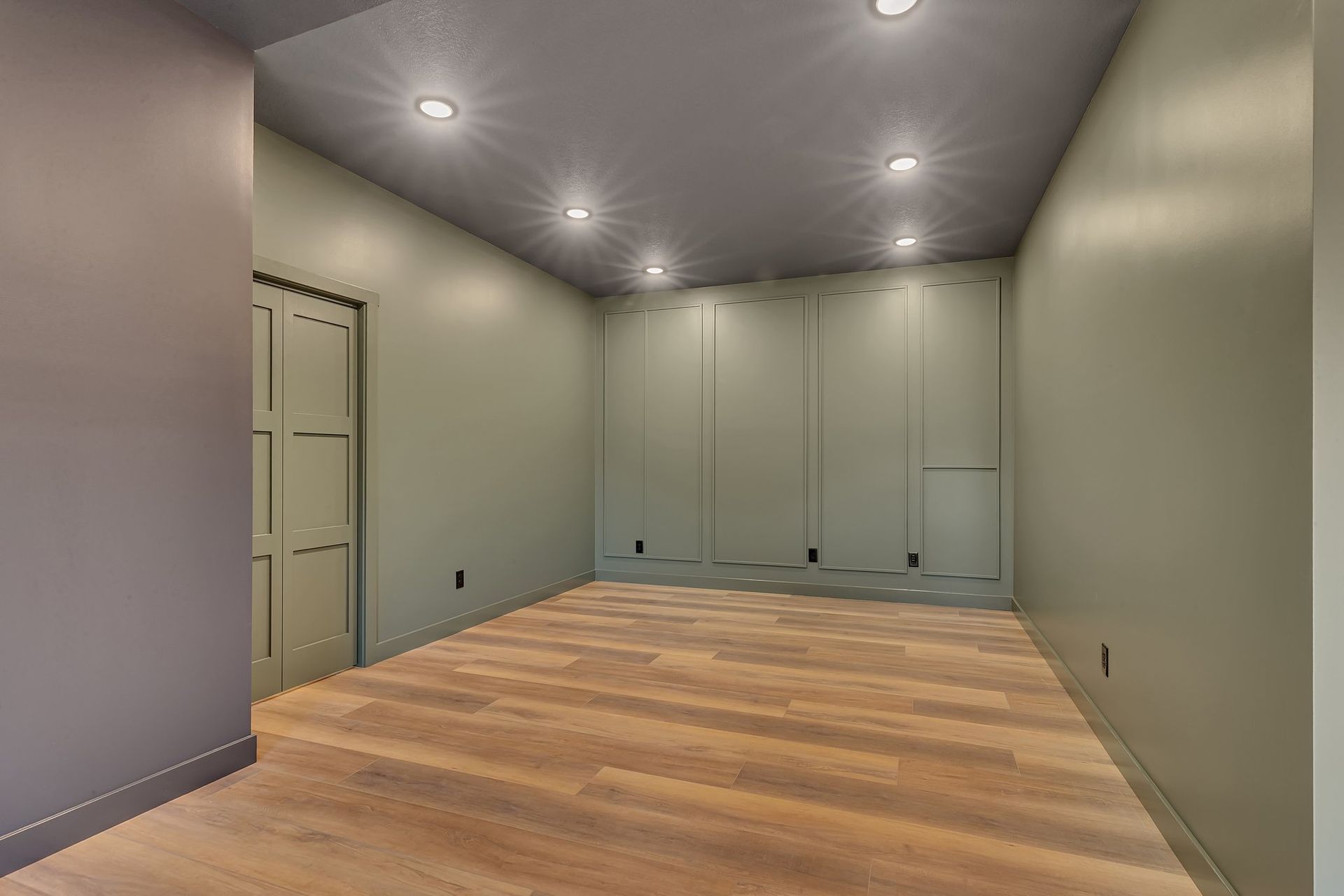 An empty room with a wooden floor and a door.