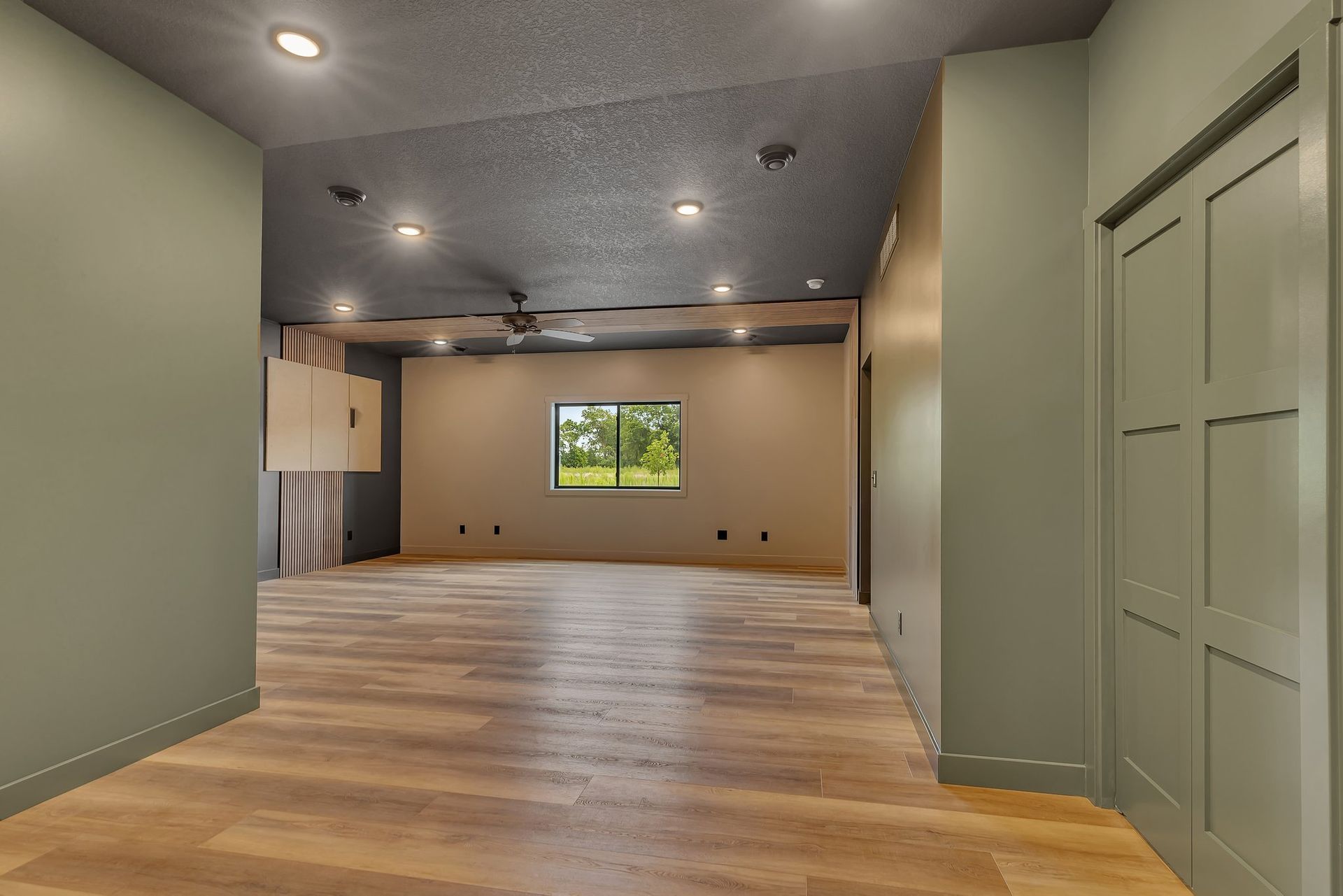 An empty room with hardwood floors and a window.