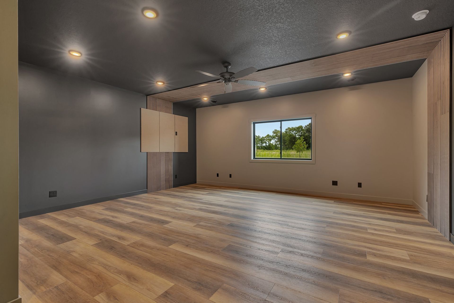 An empty room with hardwood floors and a window.
