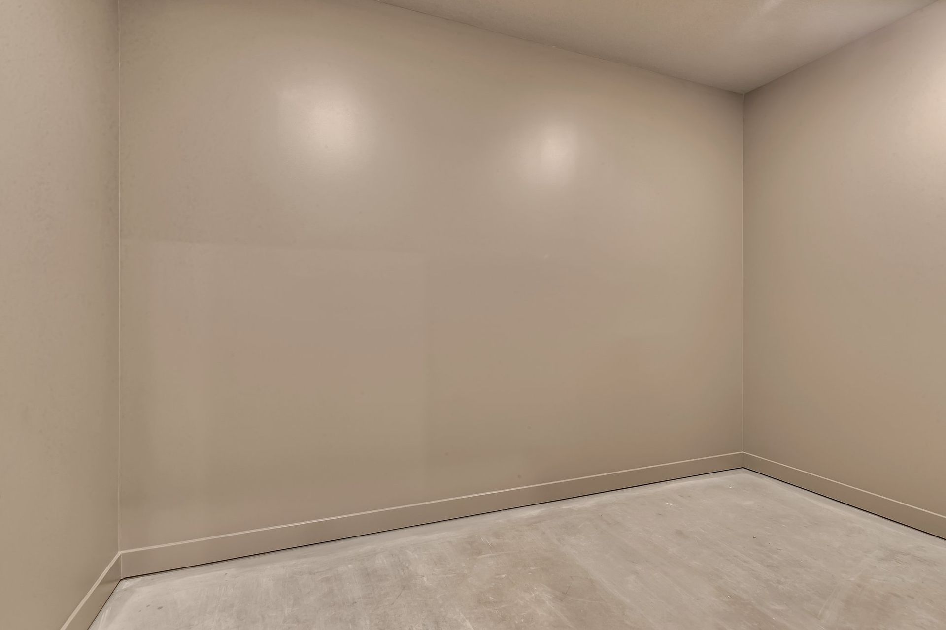 An empty room with a carpeted floor and white walls.
