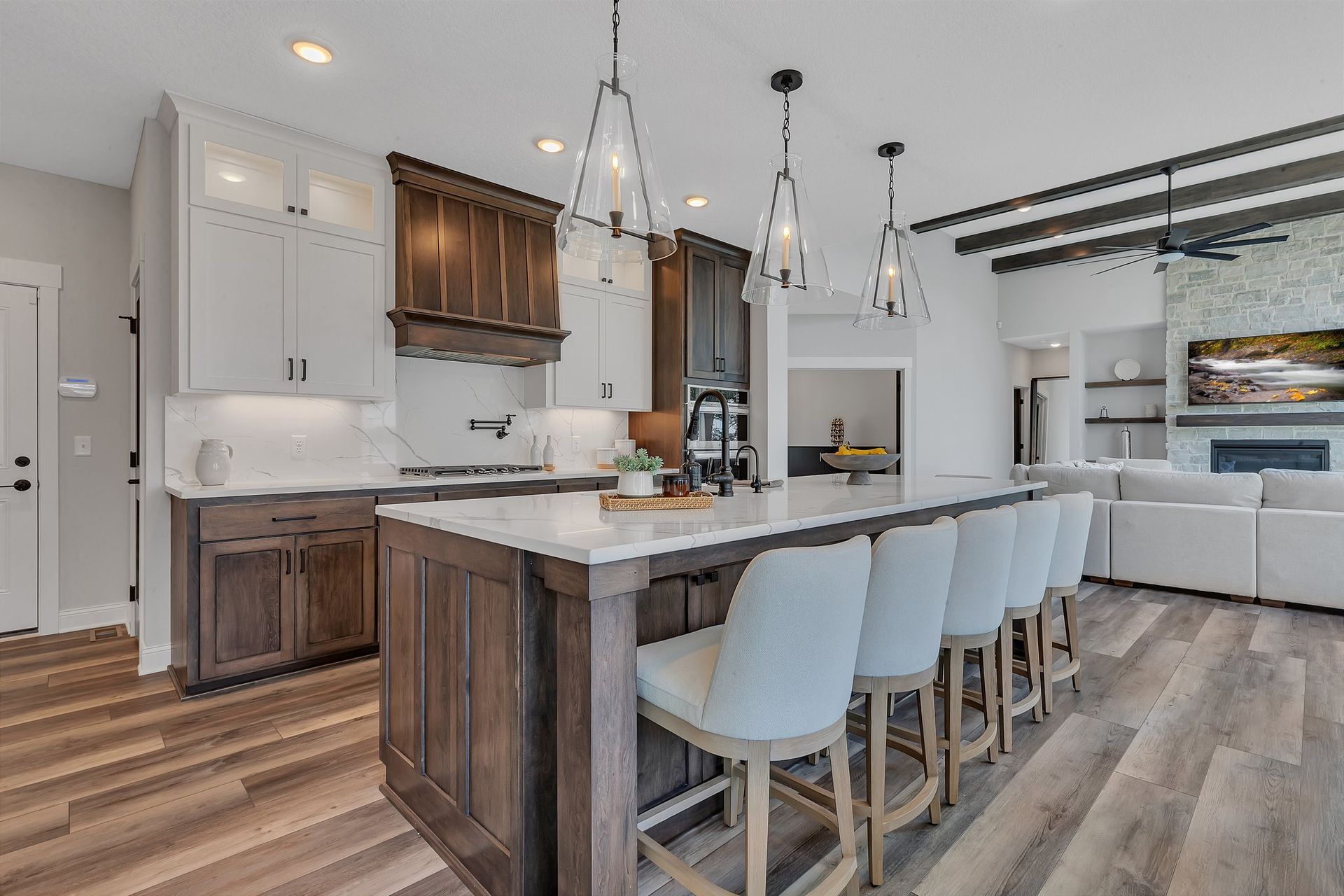 A kitchen with a large island and stools in a house.