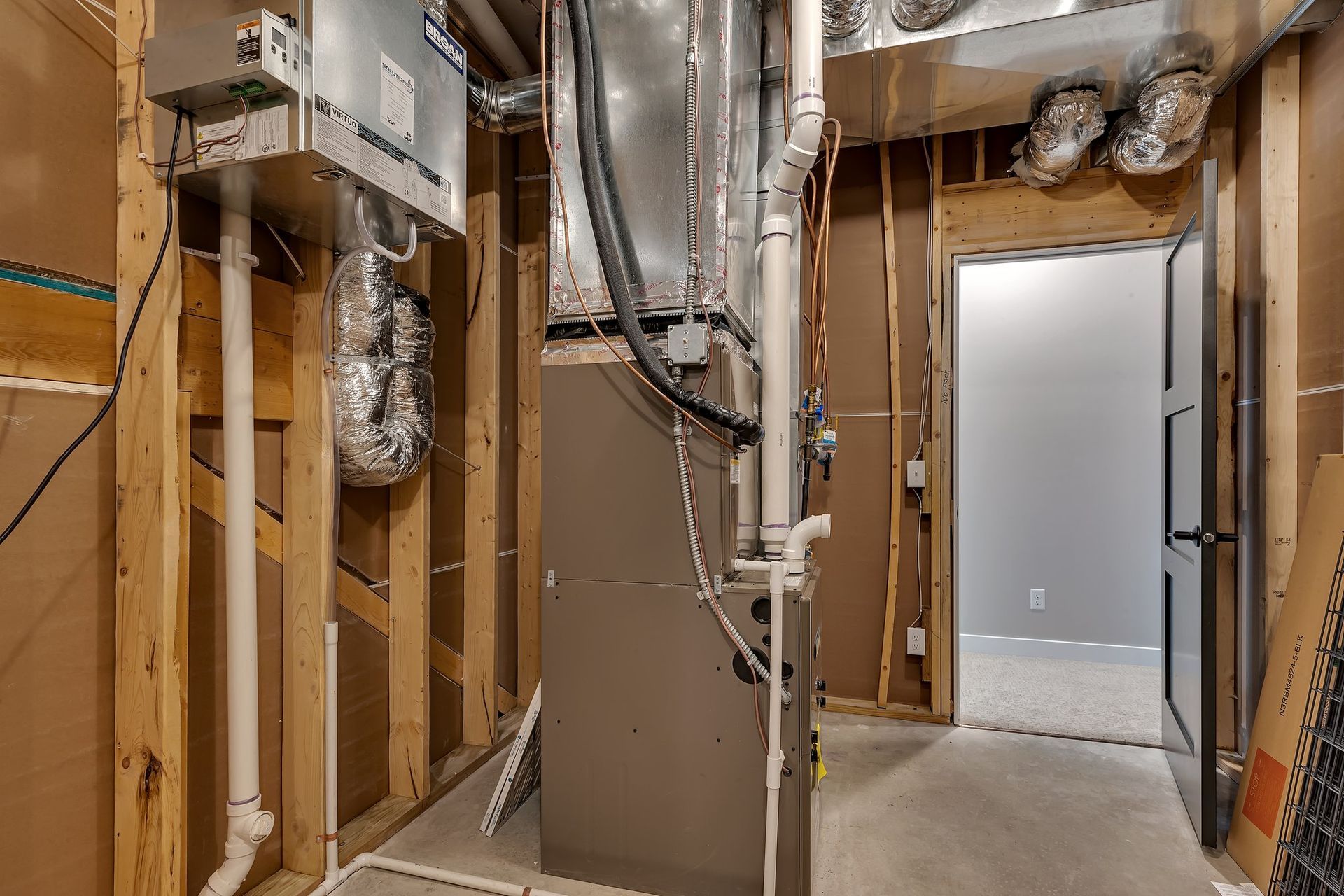 A basement with a furnace and pipes in it.