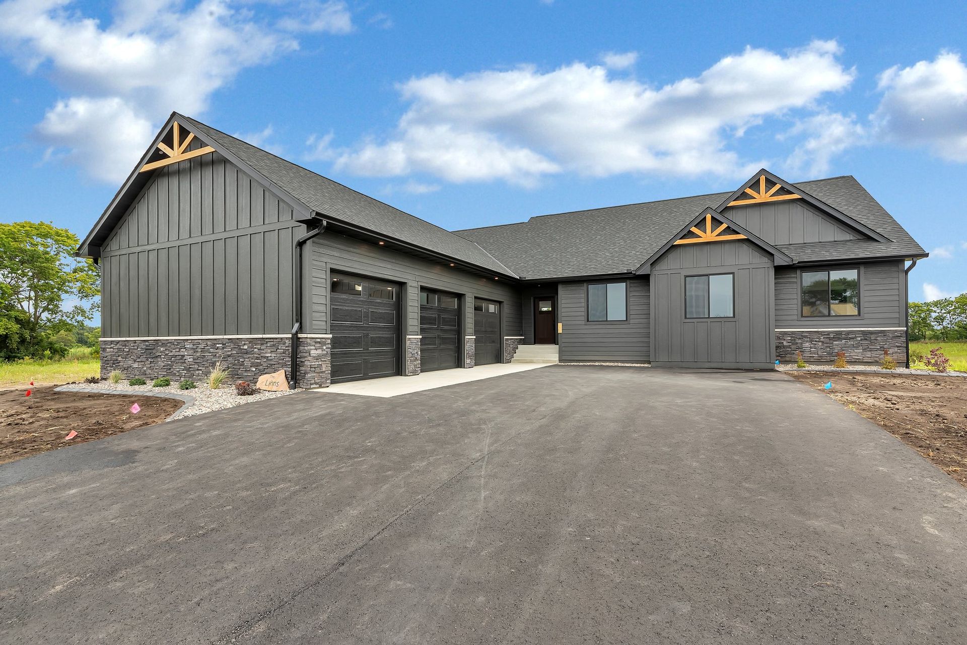 A large gray house with a driveway leading to it