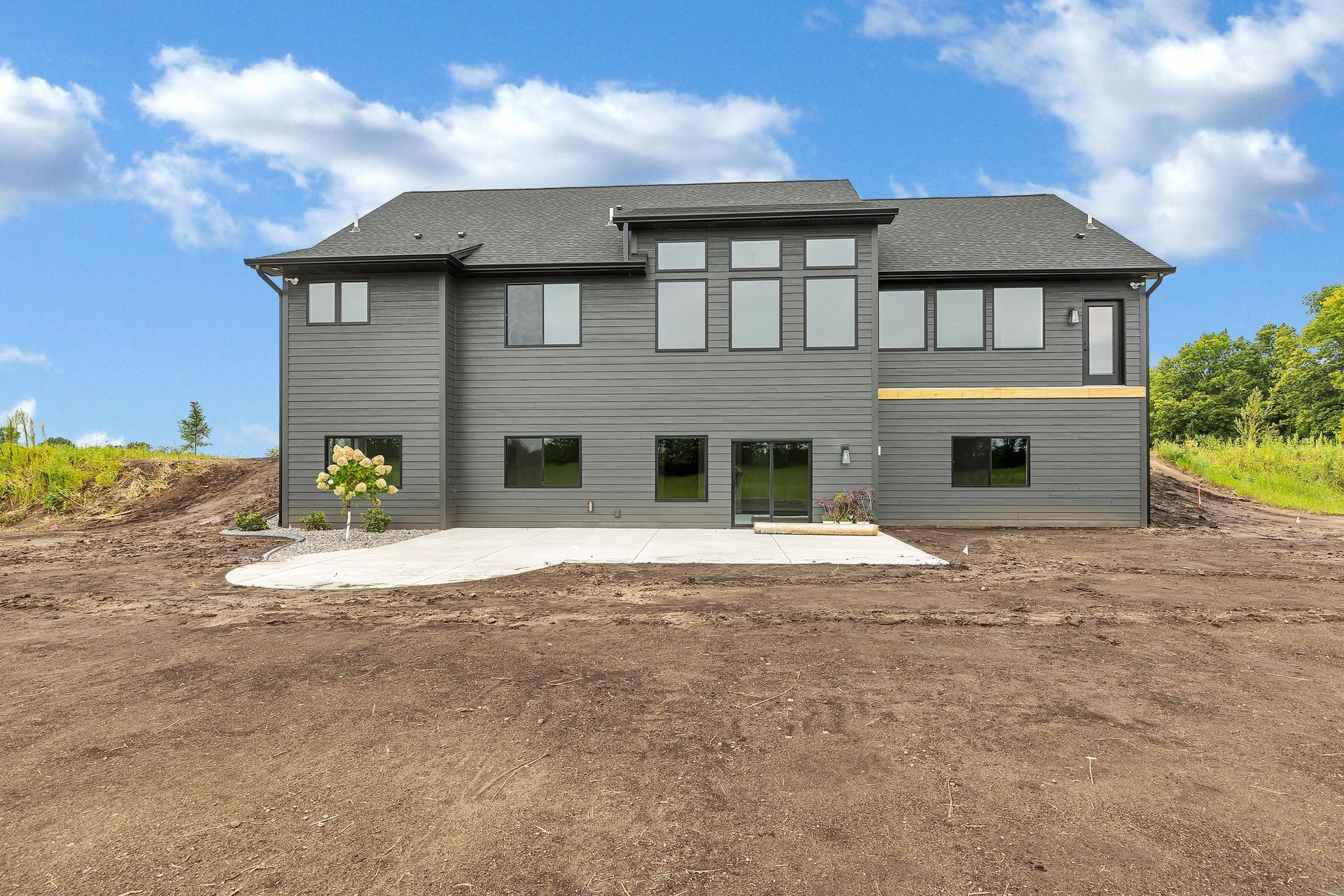 A large house is sitting on top of a dirt hill.