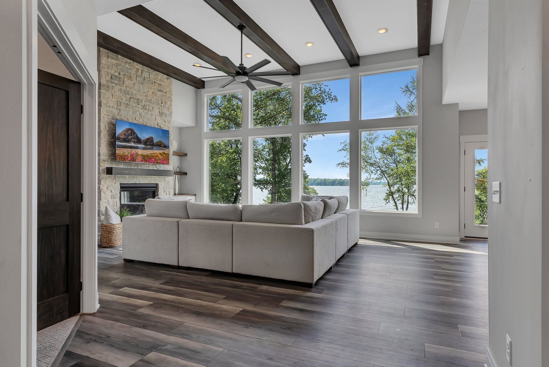 A living room with a couch , fireplace , and lots of windows.