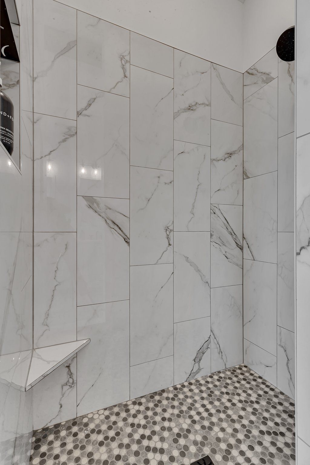 A bathroom with marble tiles and a walk in shower.