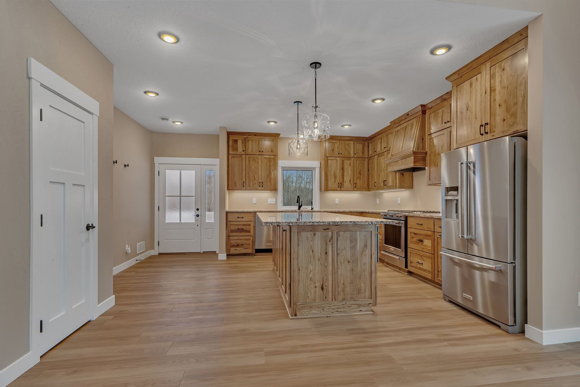 A kitchen with stainless steel appliances and wooden cabinets.