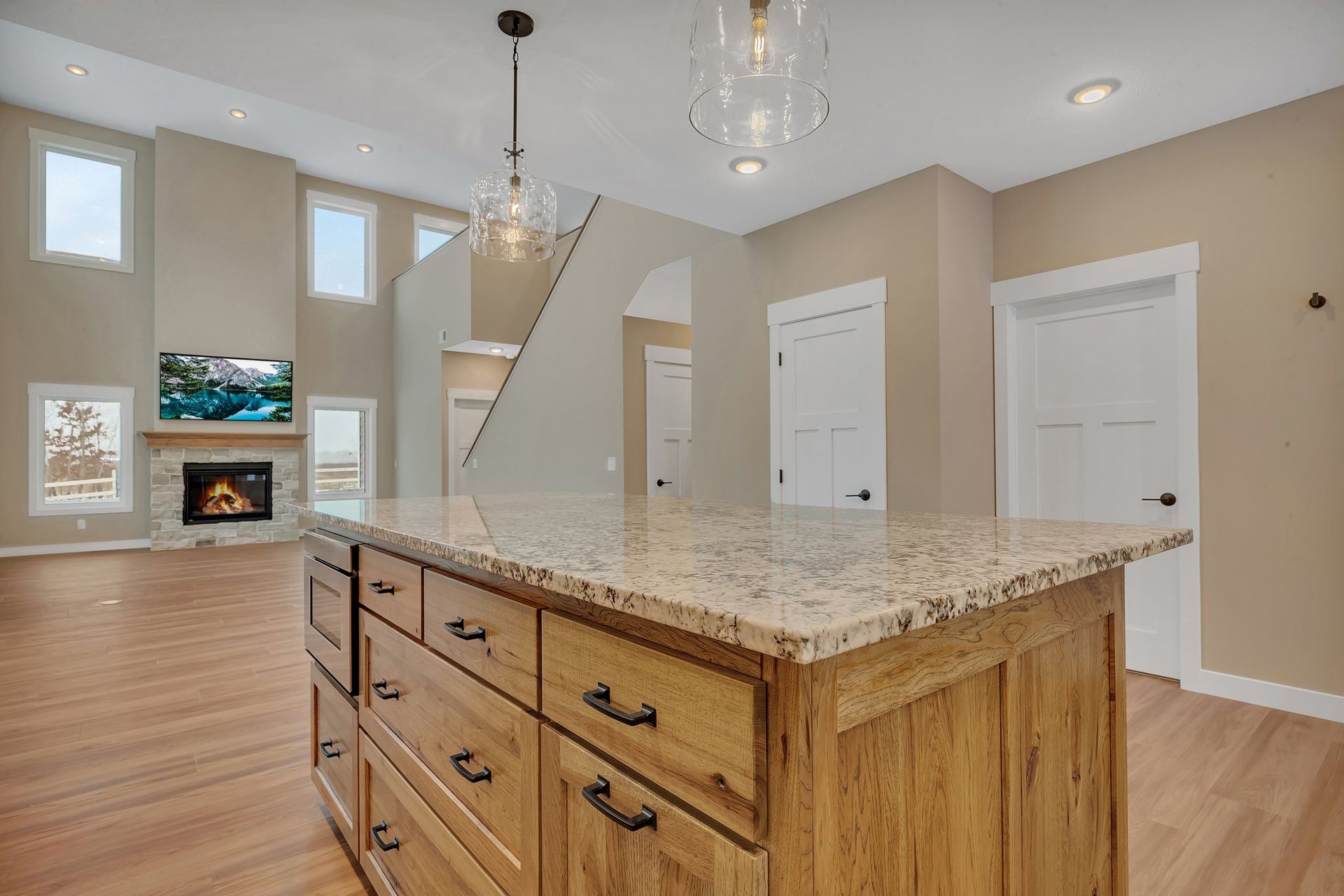 A kitchen with a large island and granite counter tops.