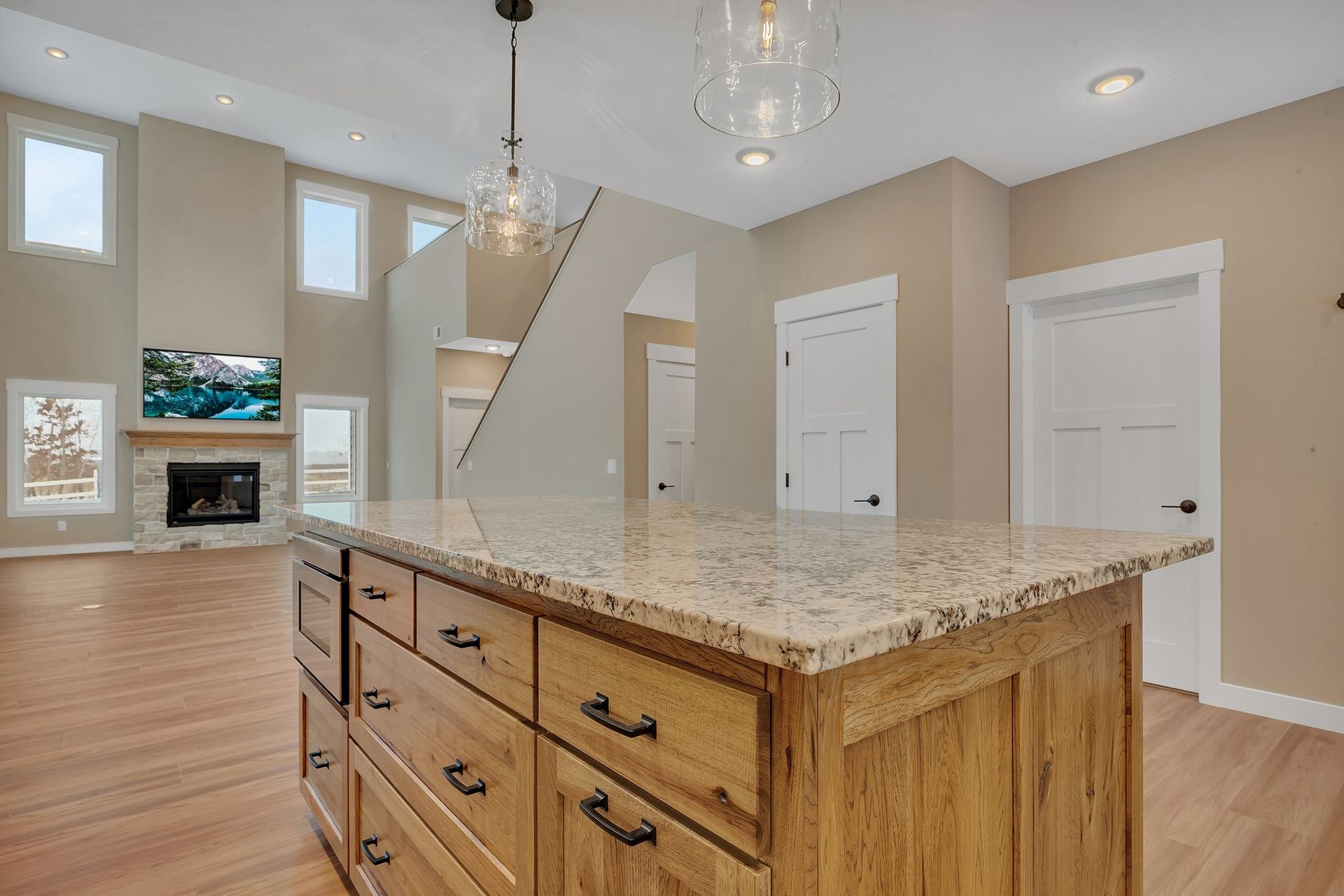 A kitchen with a large island and granite counter tops.