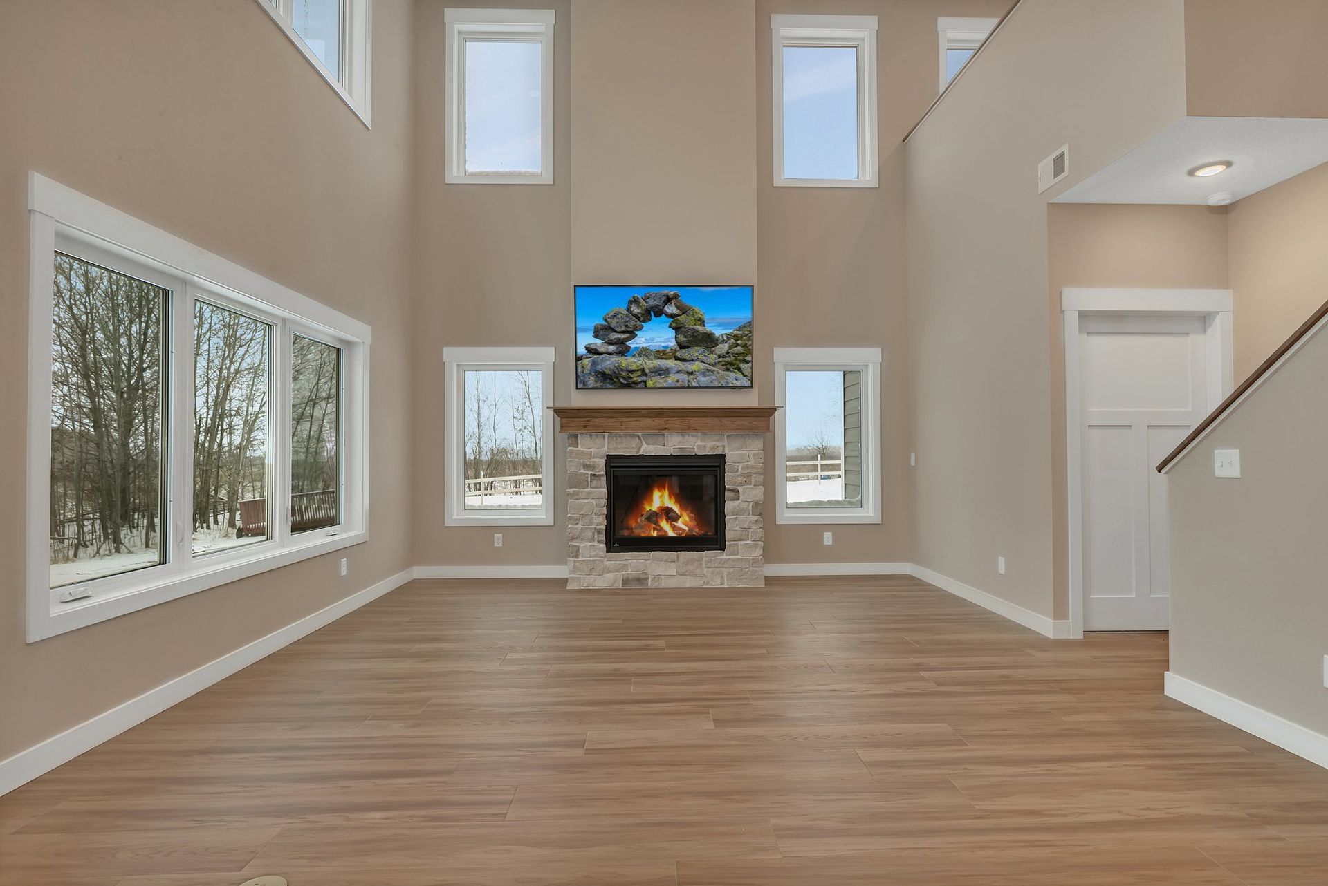 An empty living room with a fireplace and stairs