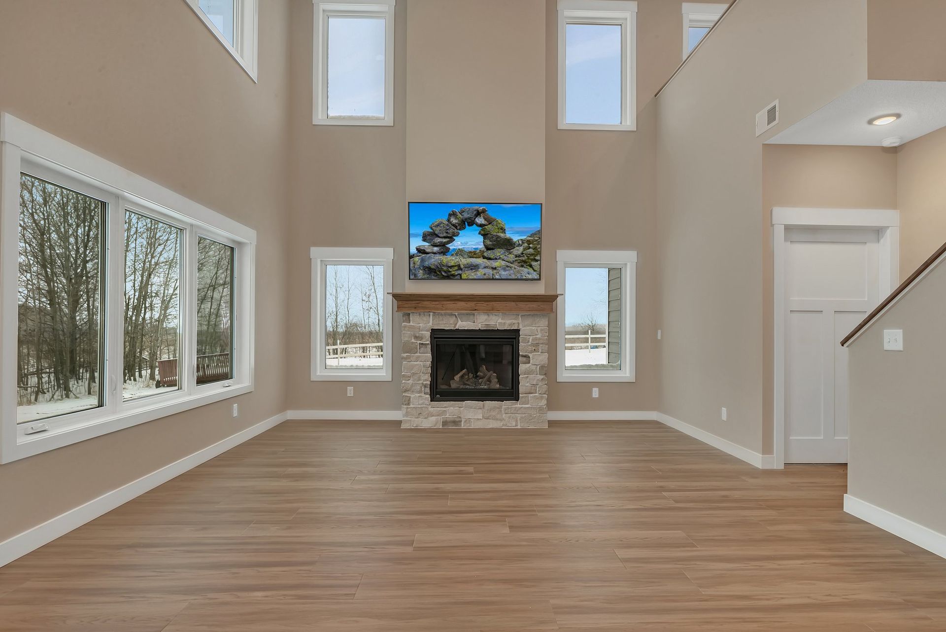 An empty living room with a fireplace and a flat screen tv