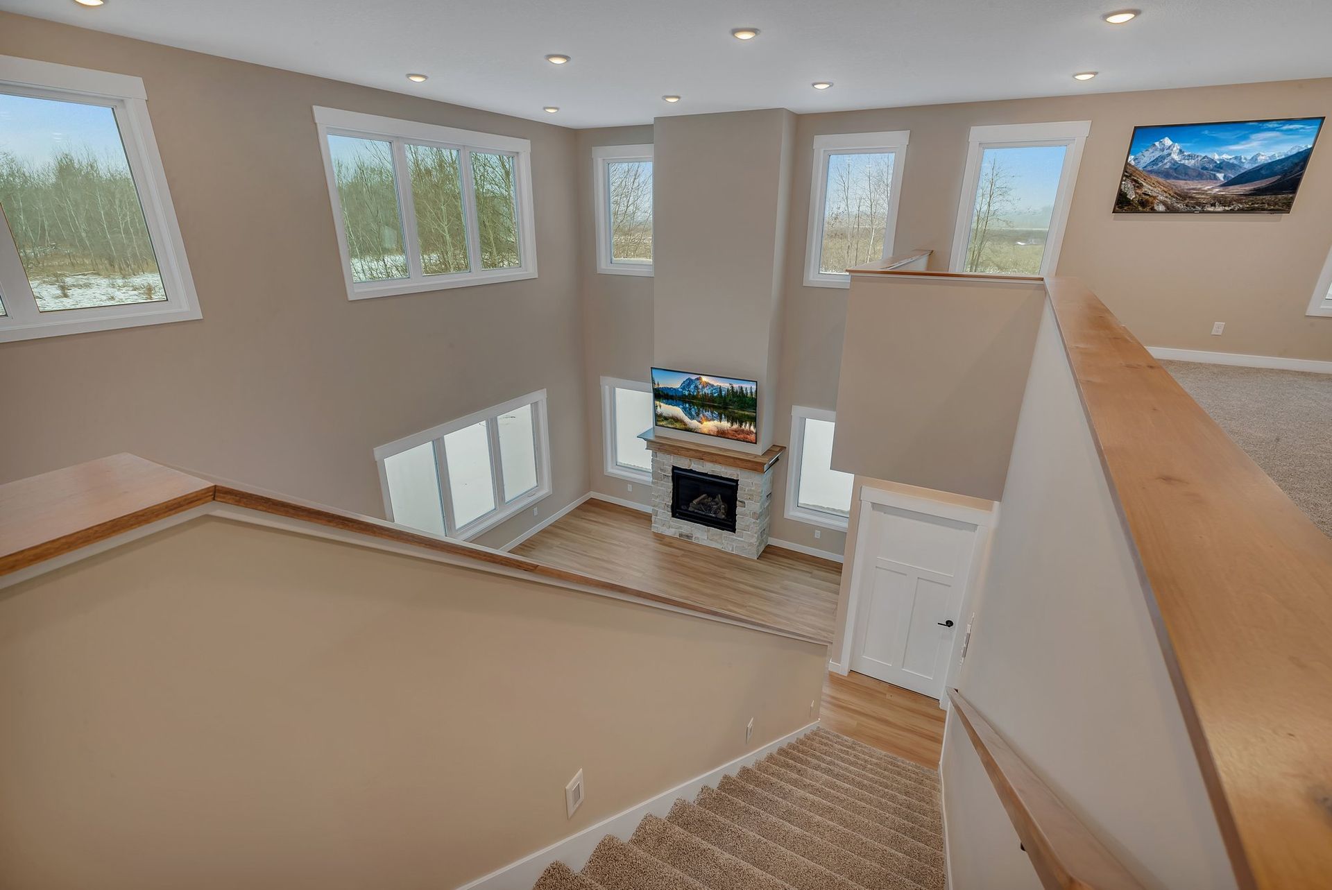 A living room with stairs leading up to it and a fireplace.
