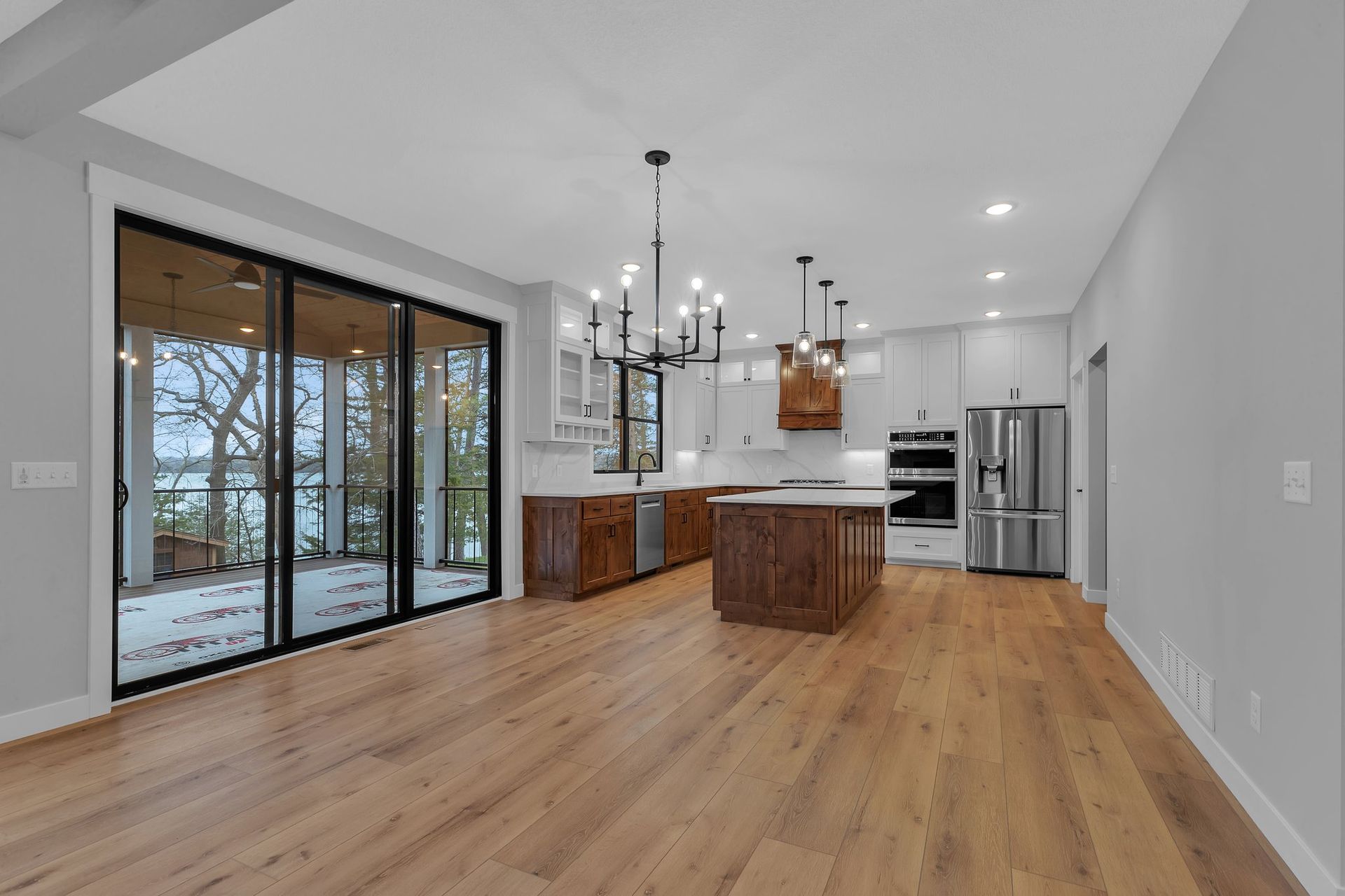 A large empty kitchen with hardwood floors and sliding glass doors.