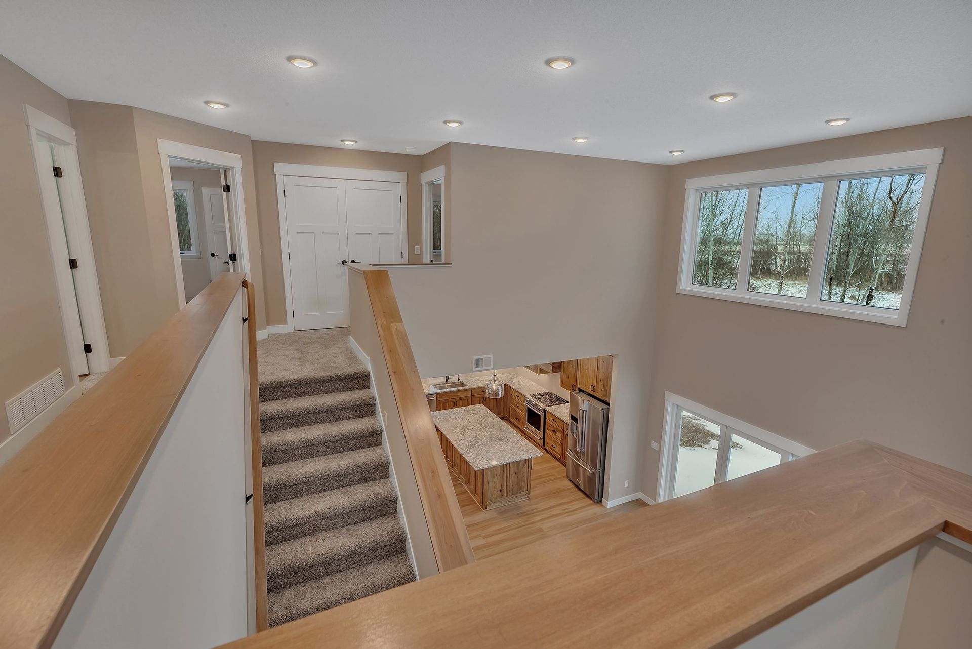 A view of a kitchen and stairs from the second floor of a house.