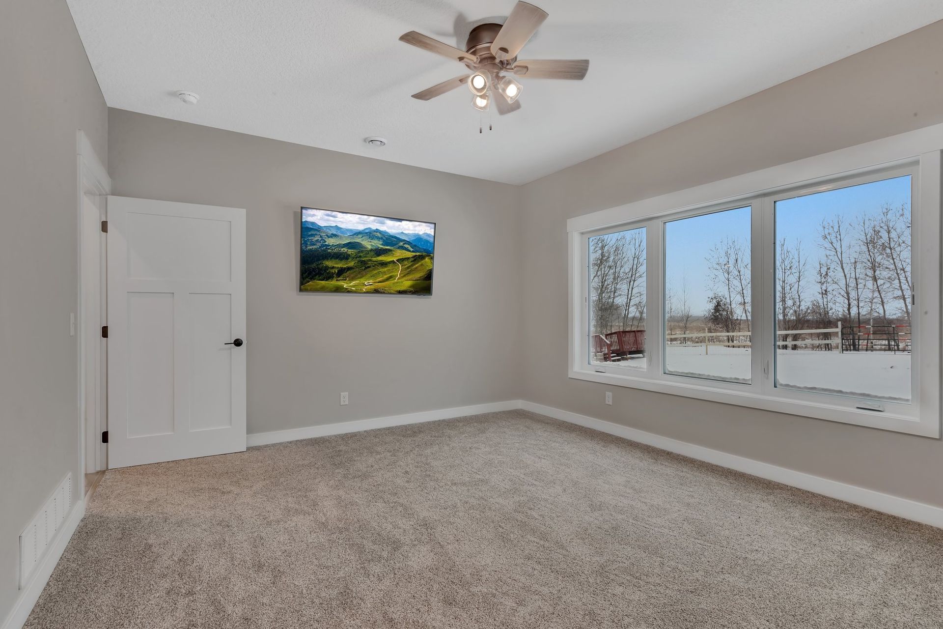 An empty bedroom with a ceiling fan and a picture on the wall.