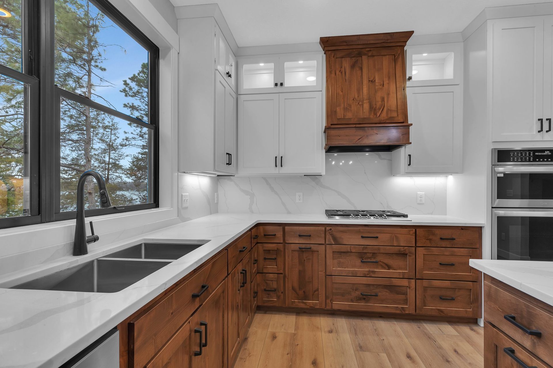A kitchen with two sinks , a stove , and a window.