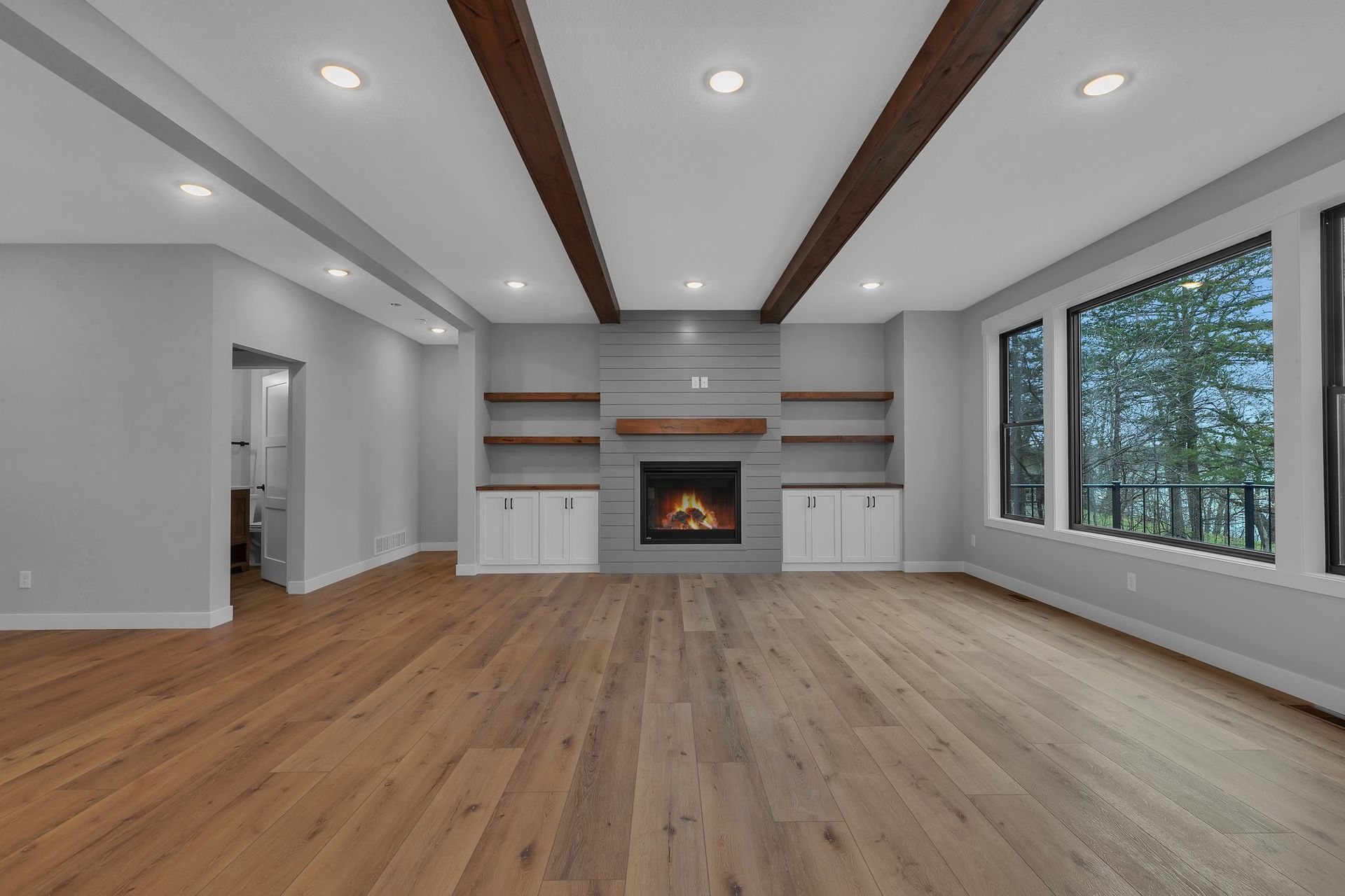 An empty living room with hardwood floors and a fireplace.
