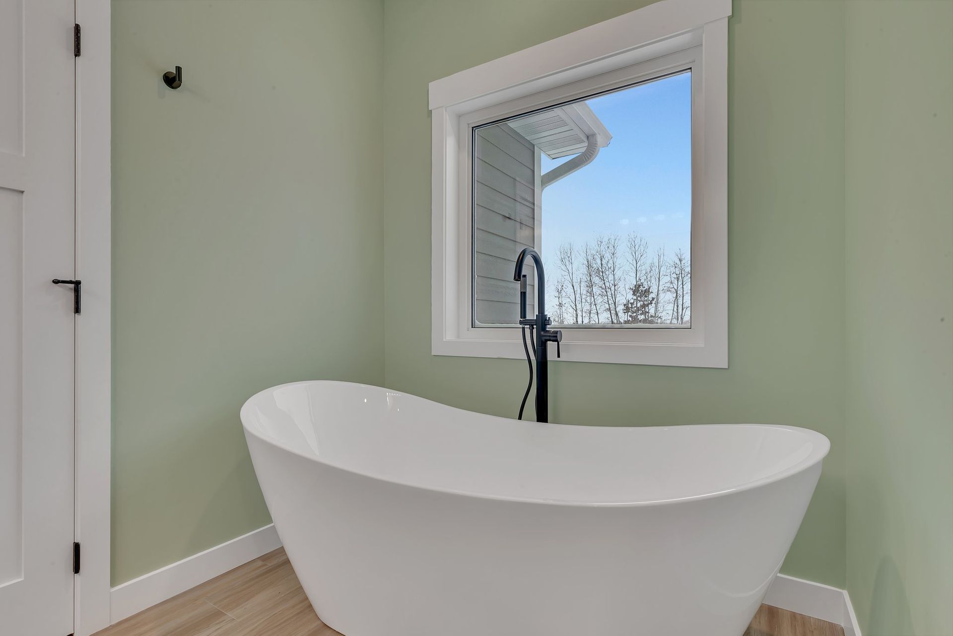 A bathroom with a bathtub and a window.