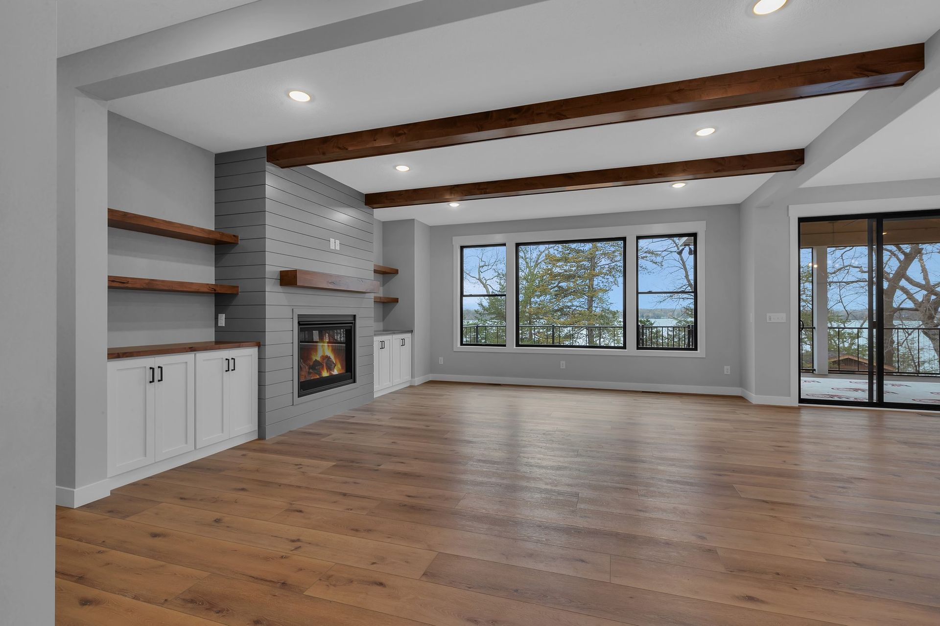 An empty living room with hardwood floors and a fireplace.