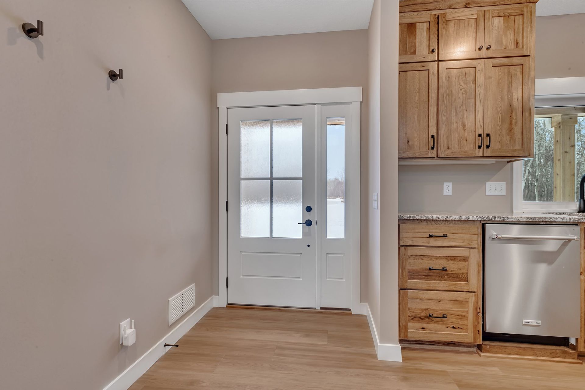 A kitchen with wooden cabinets and a stainless steel dishwasher.