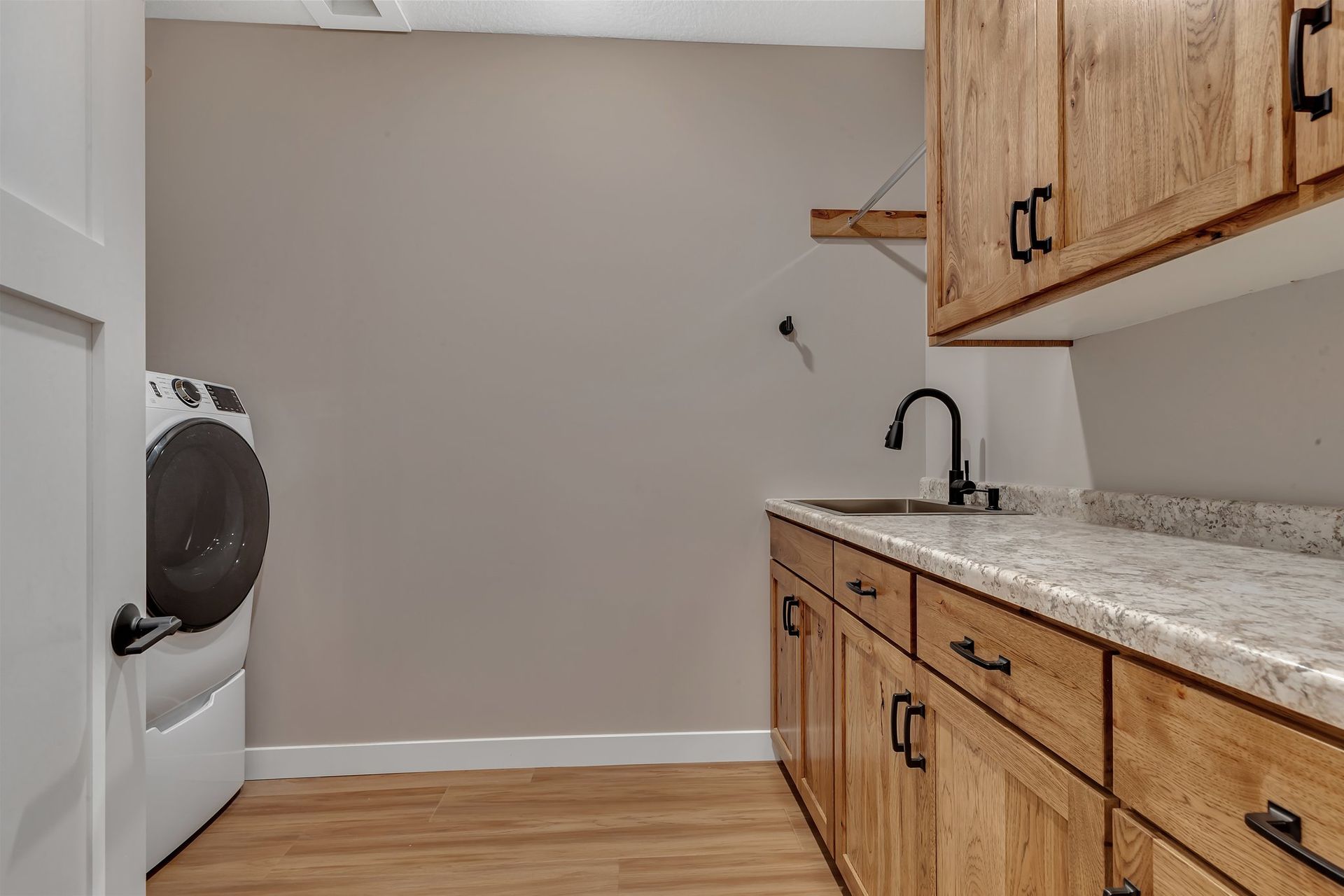 A laundry room with a washer and dryer and a sink.