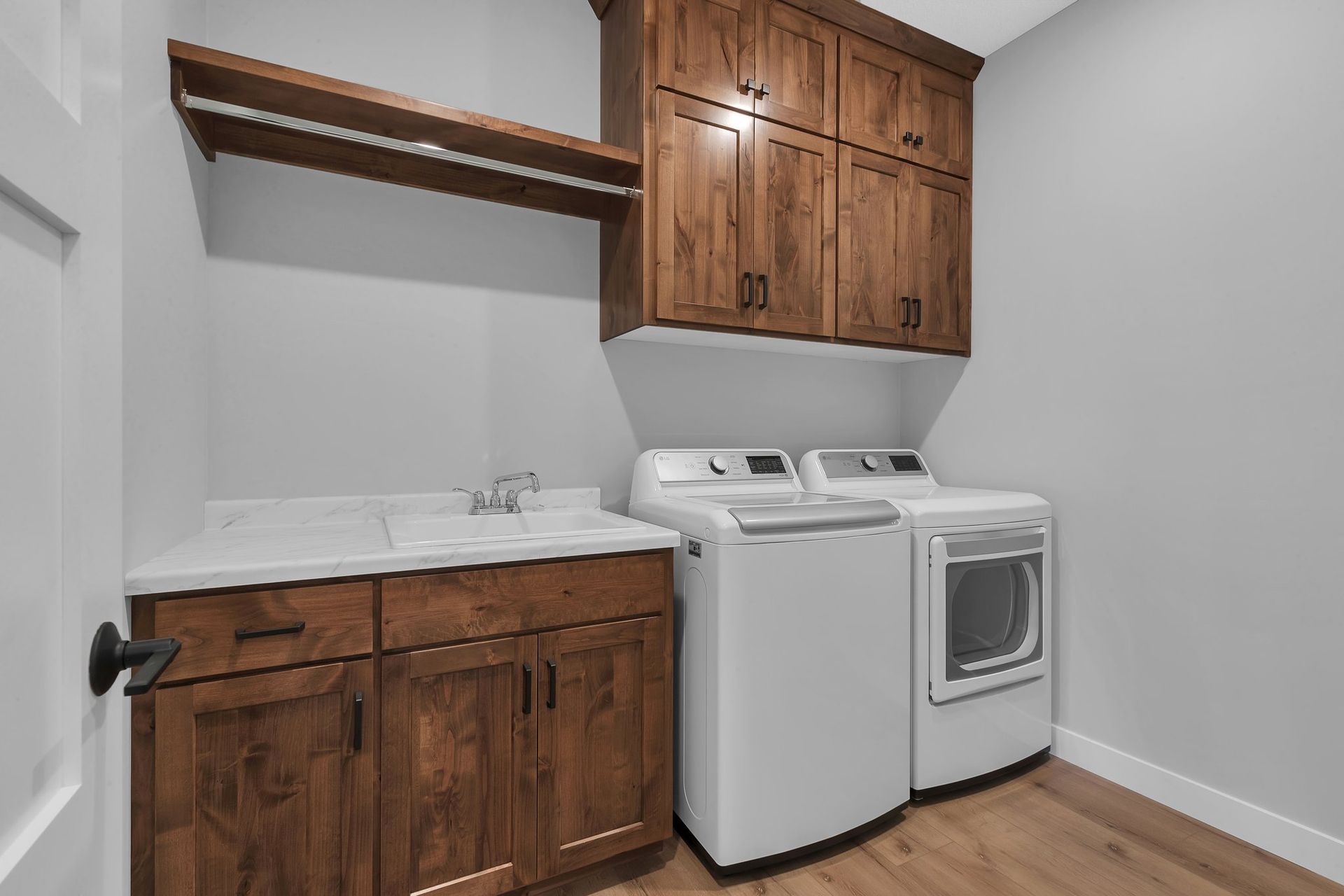 A laundry room with a washer and dryer and wooden cabinets.