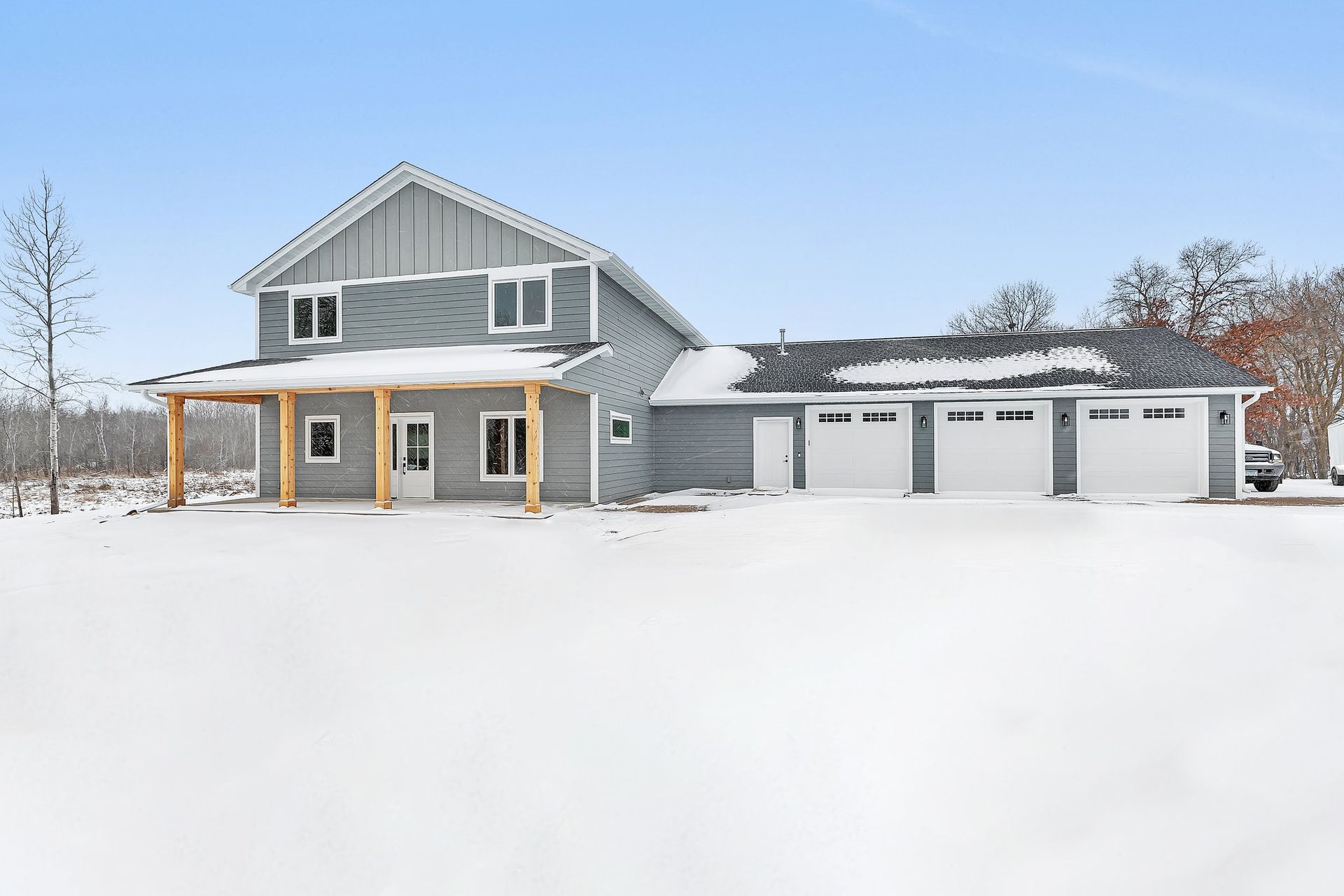 A large house is sitting in the middle of a snow covered field.