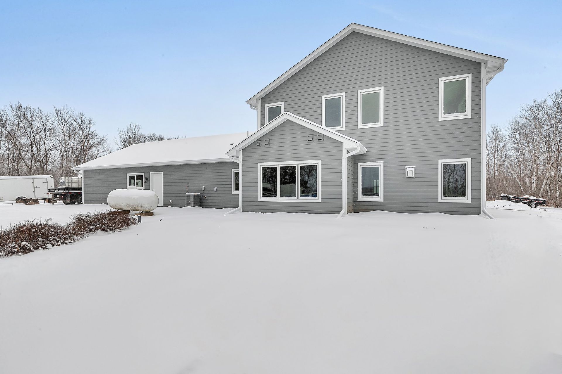A large house with a lot of windows is covered in snow.