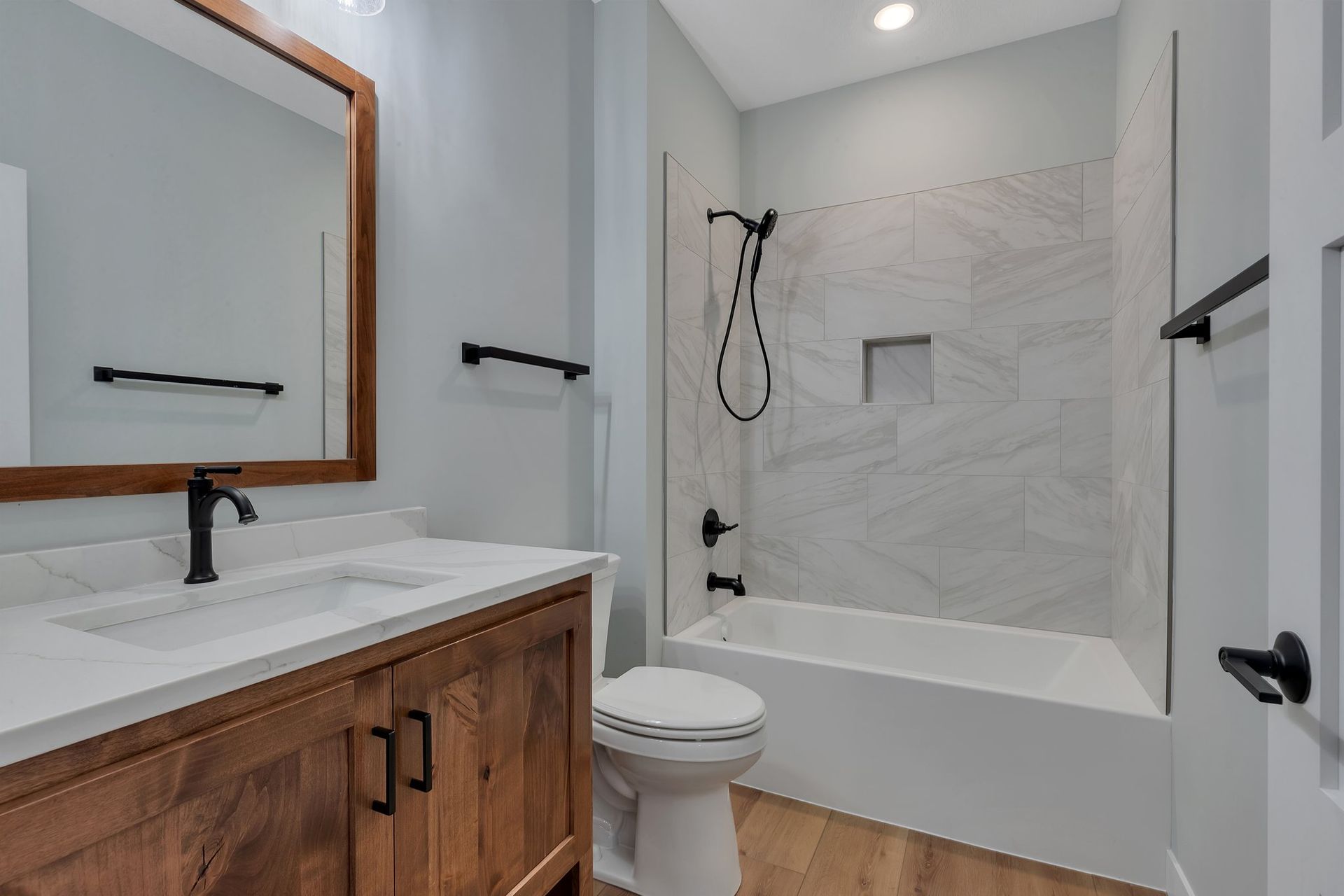 A bathroom with a toilet , sink , mirror and bathtub.