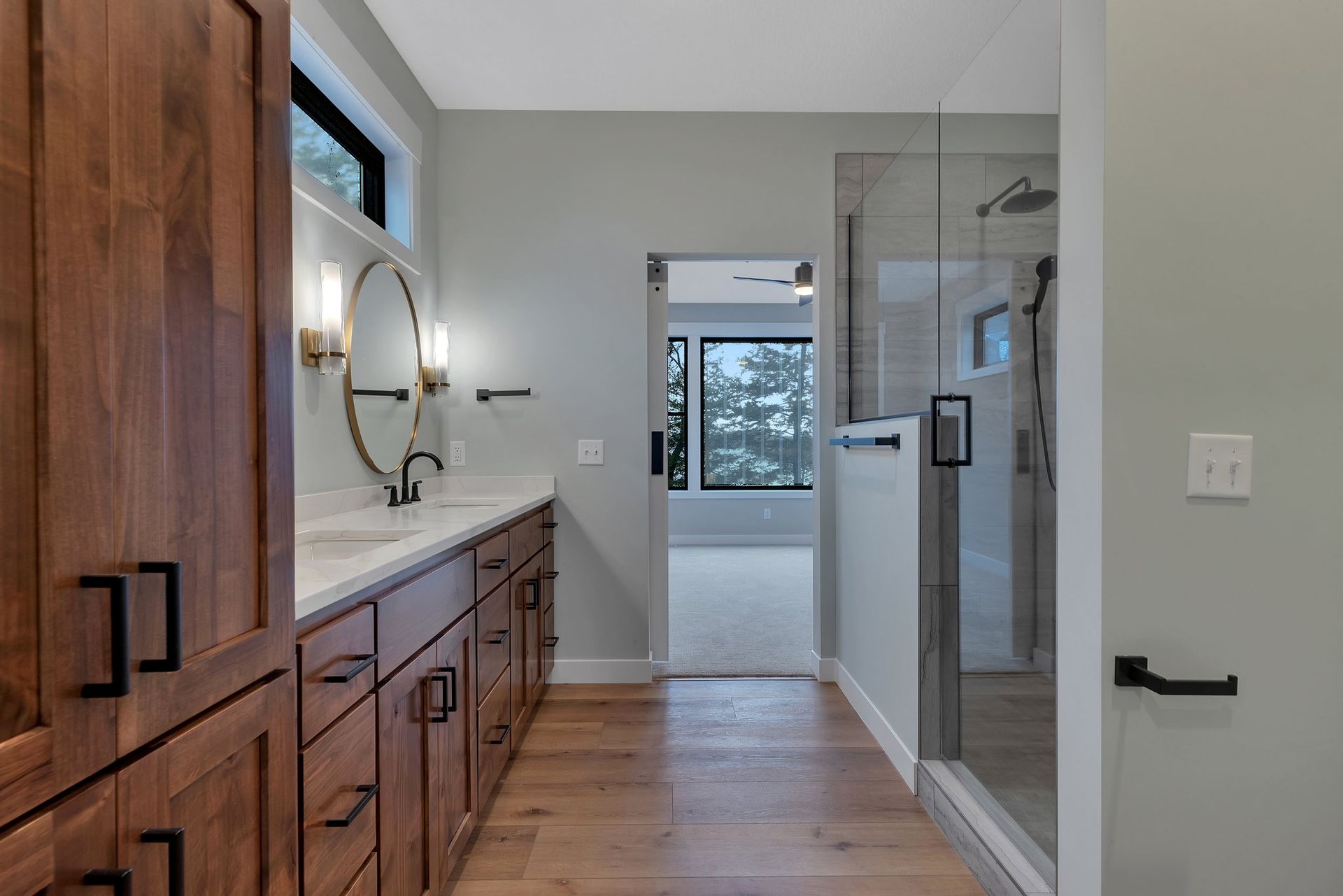 A bathroom with a sink , cabinets , and a walk in shower.