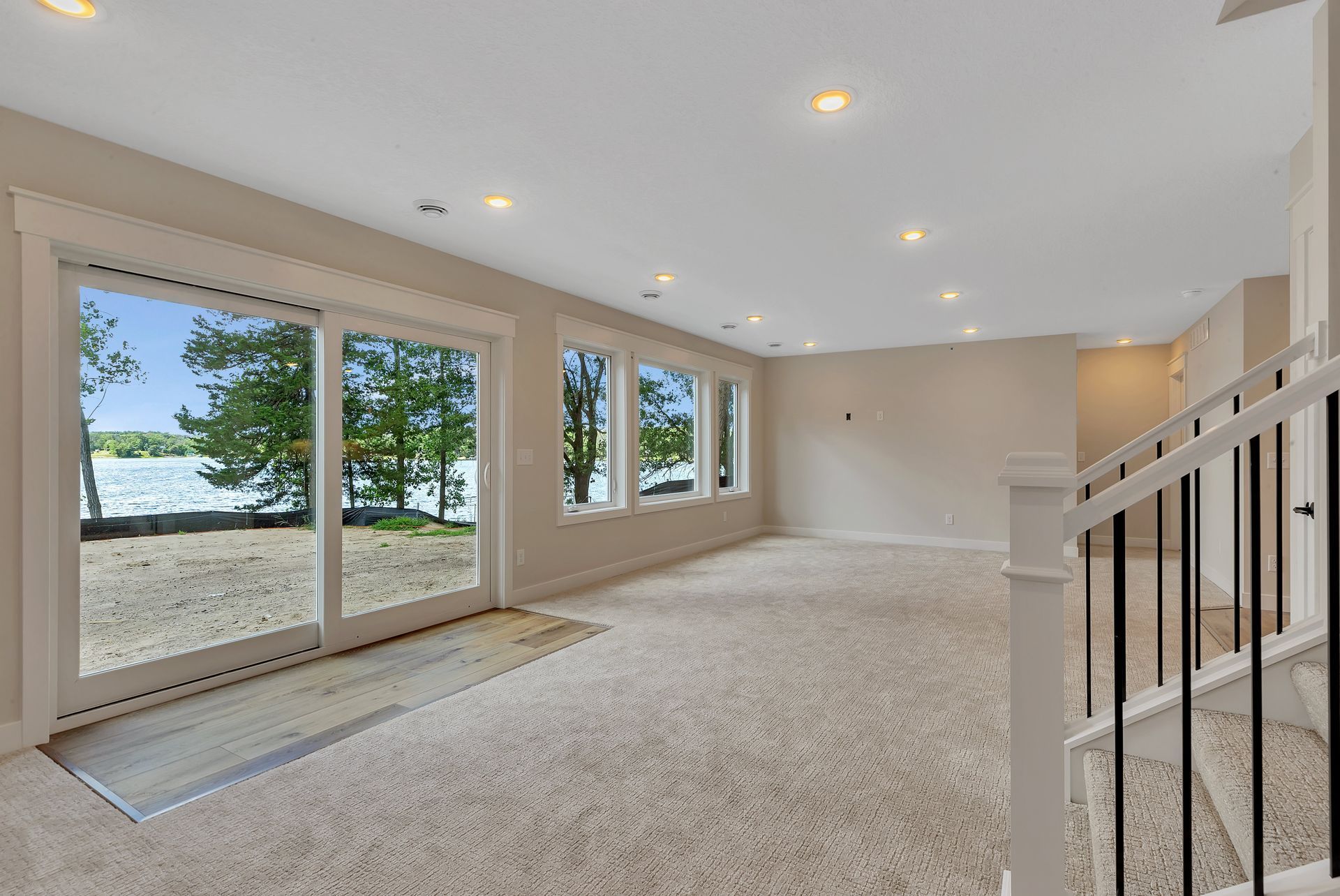A large empty room with a lot of windows and stairs.