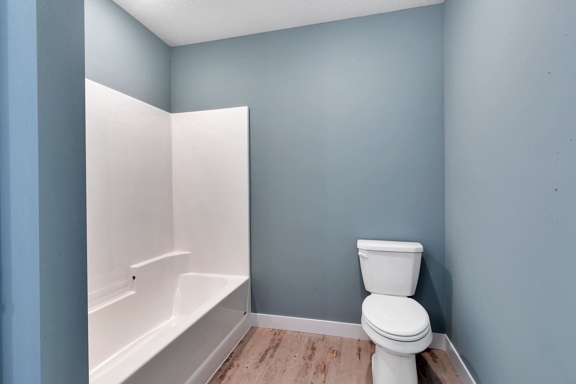 A bathroom with a toilet , bathtub and shower.