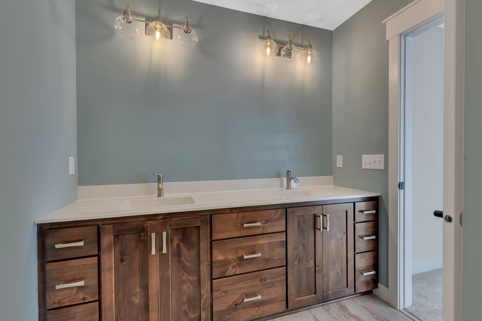 A bathroom with two sinks and wooden cabinets.