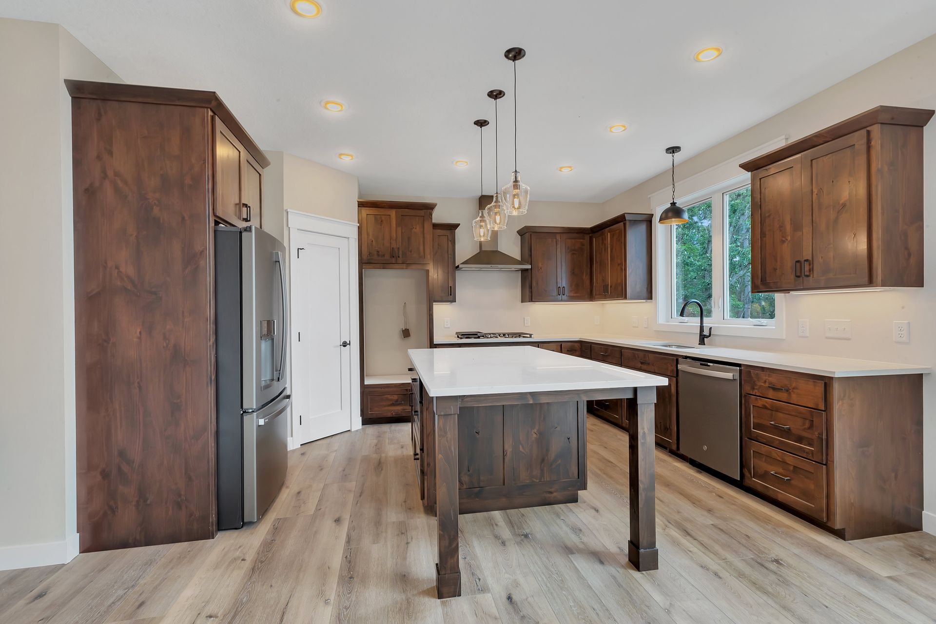 A kitchen with wooden cabinets , stainless steel appliances , and a large island.