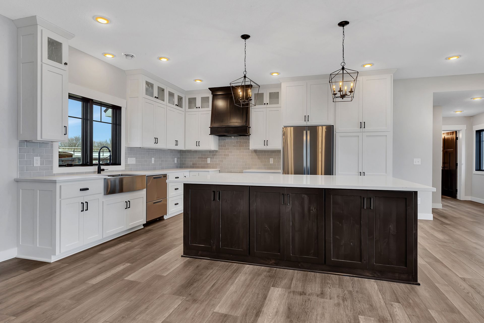 A kitchen with white cabinets and a large island in the middle.