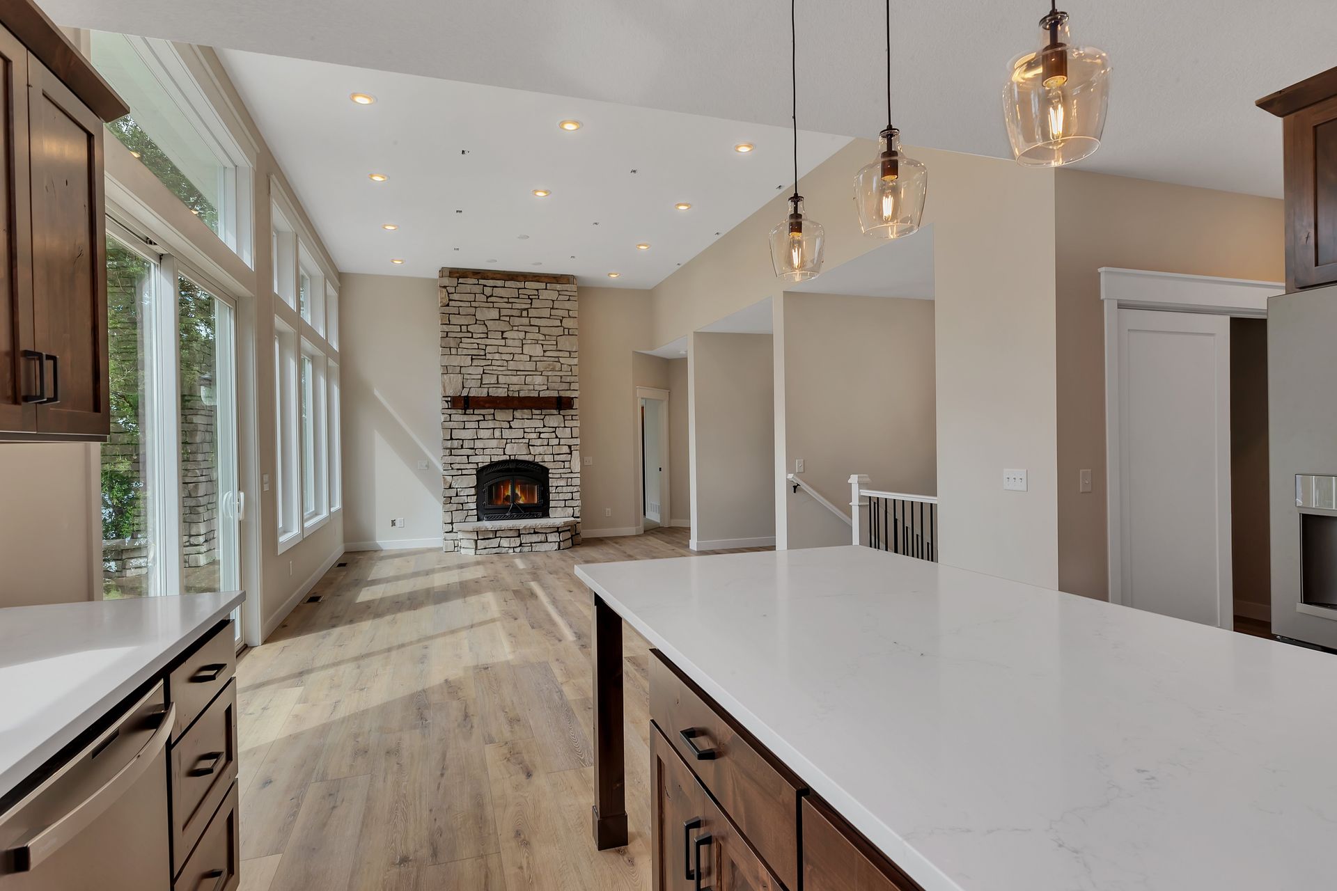 A kitchen with a large island and a fireplace in the background.