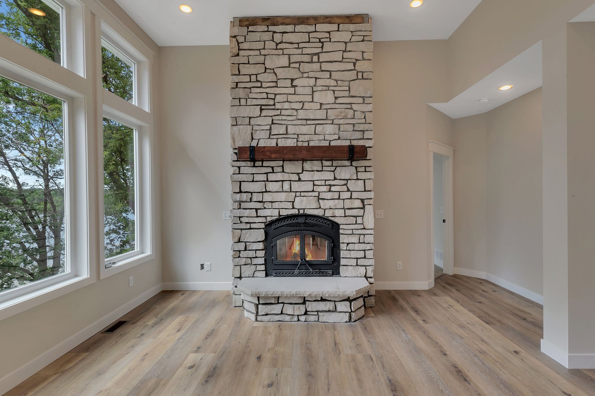 There is a large stone fireplace in the middle of the room.