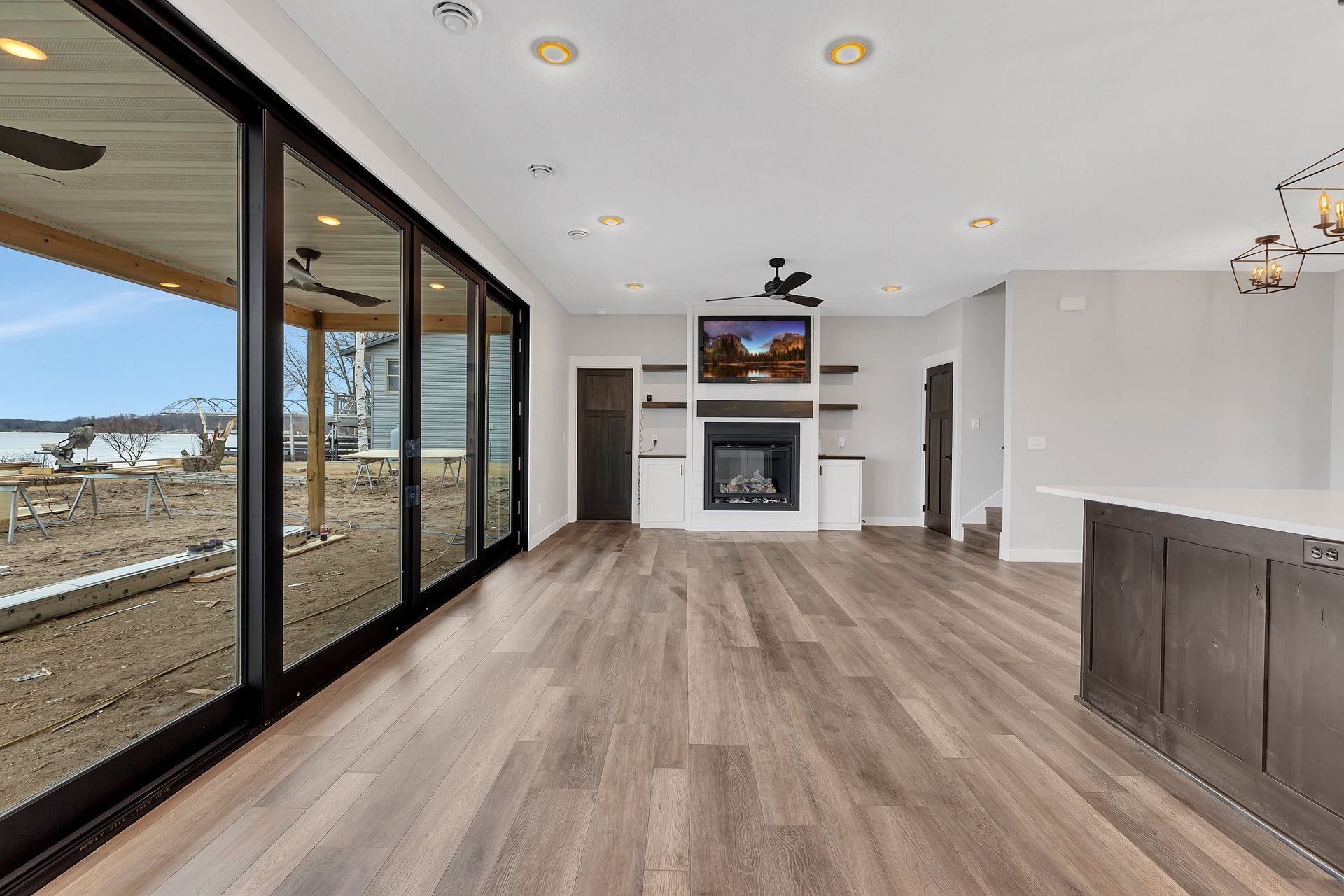 A living room with a fireplace , television , and sliding glass doors.