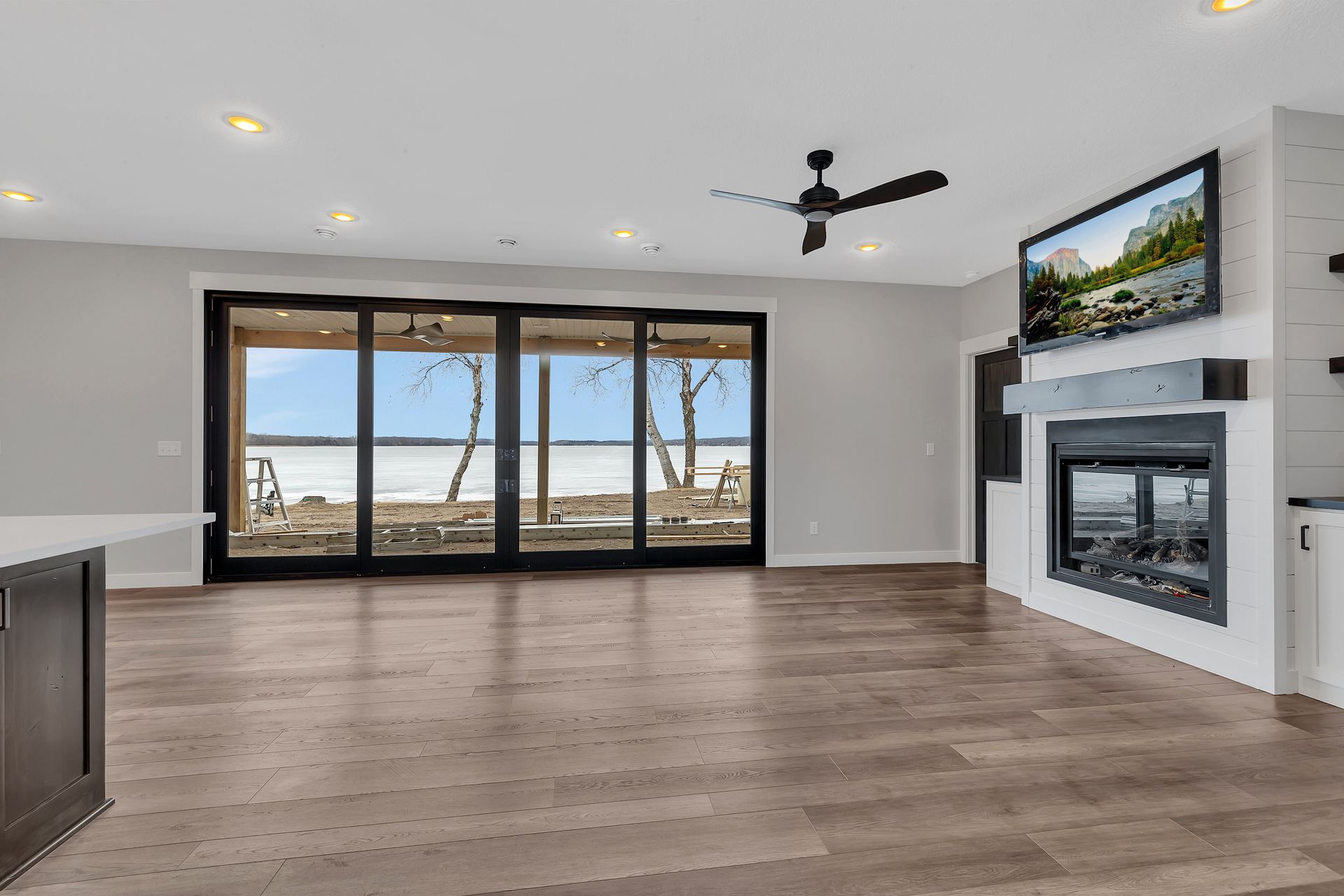 An empty living room with a fireplace and a television.