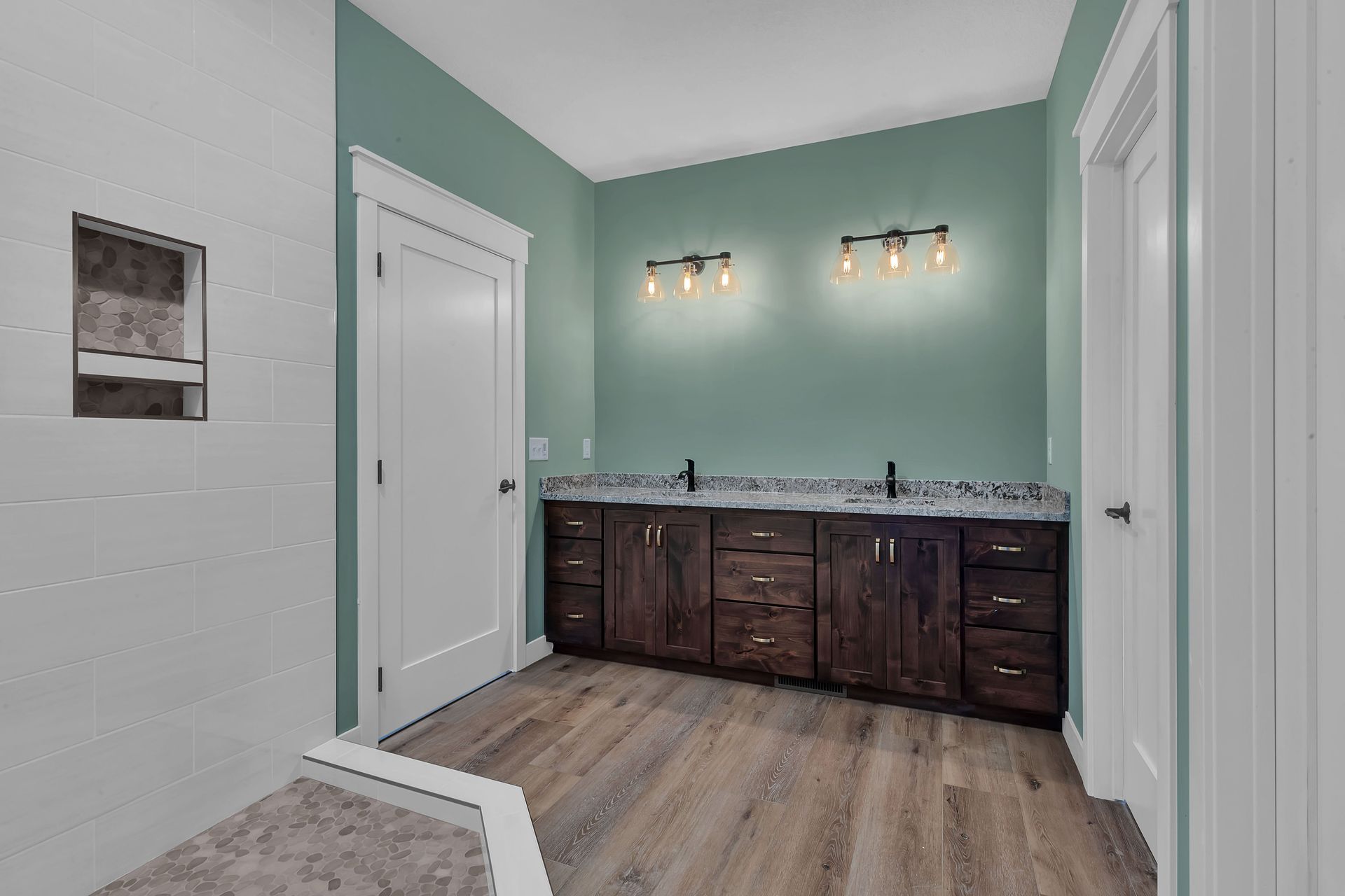 A bathroom with two sinks and wooden floors in a house.