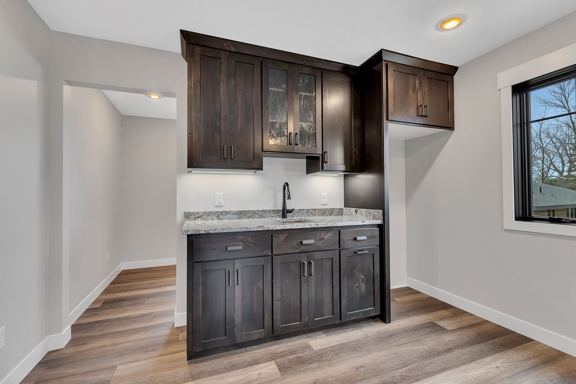 A kitchen with a sink , cabinets and a window.