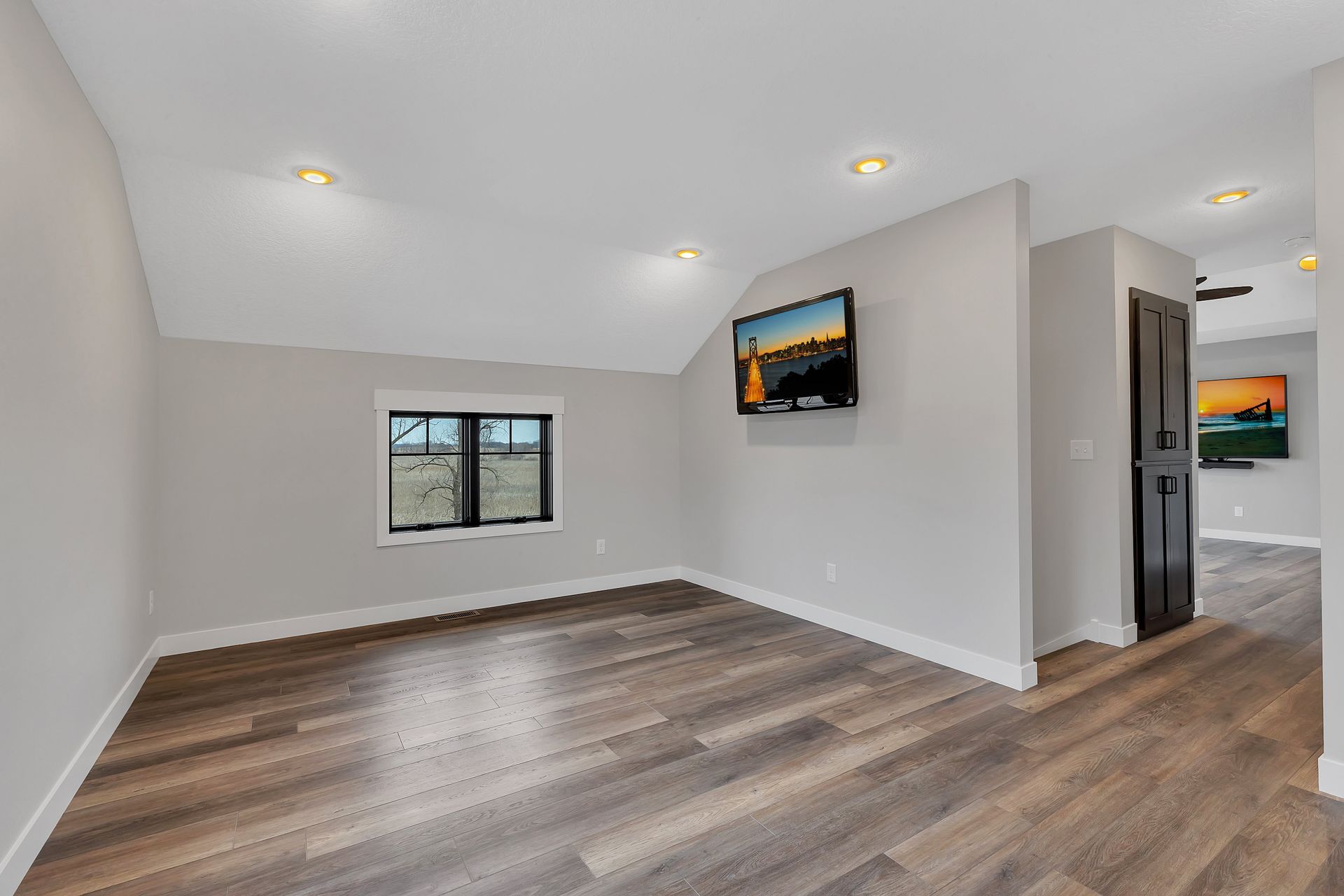 A living room with hardwood floors and a flat screen tv on the wall.