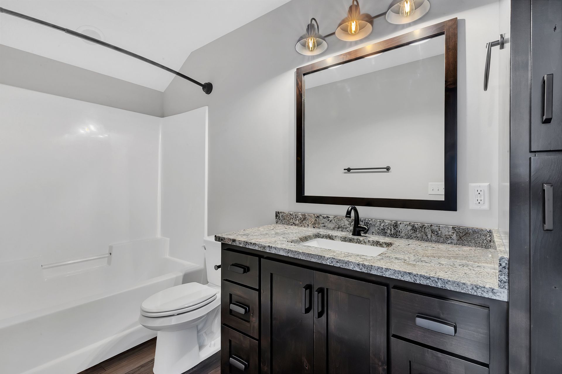 A bathroom with a toilet , sink , mirror and bathtub.