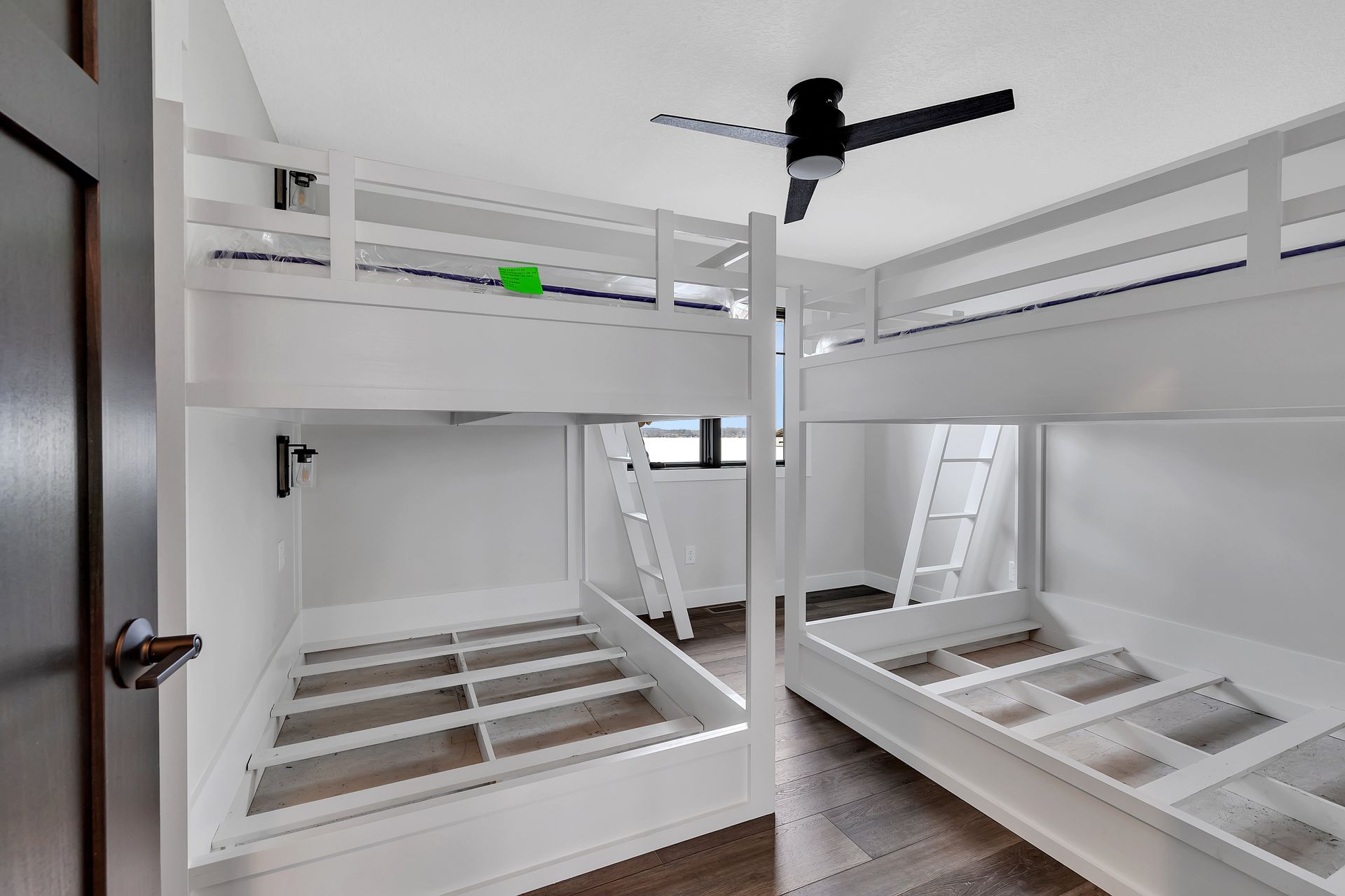 A bedroom with three bunk beds and a ceiling fan.
