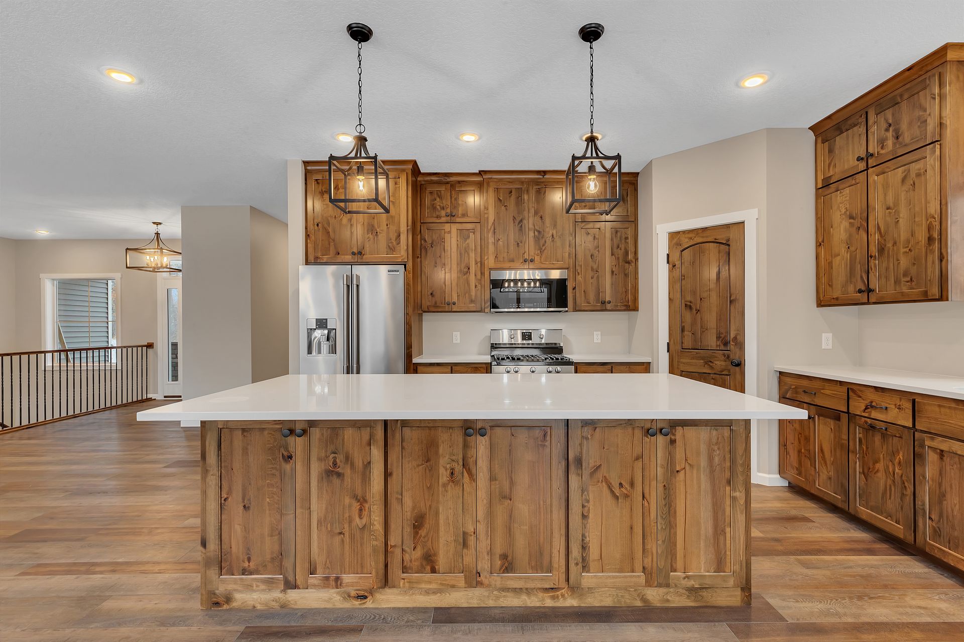 A kitchen with wooden cabinets and a large island in the middle.