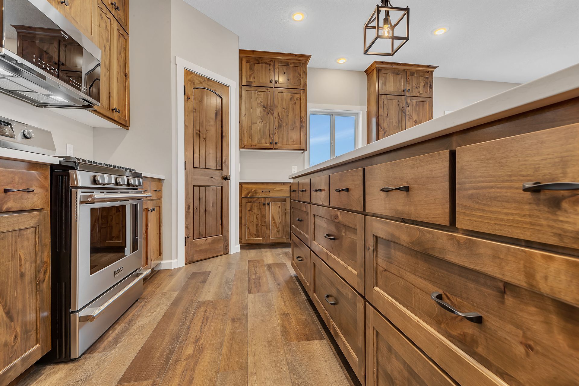 A kitchen with wooden cabinets , stainless steel appliances , and a large island.