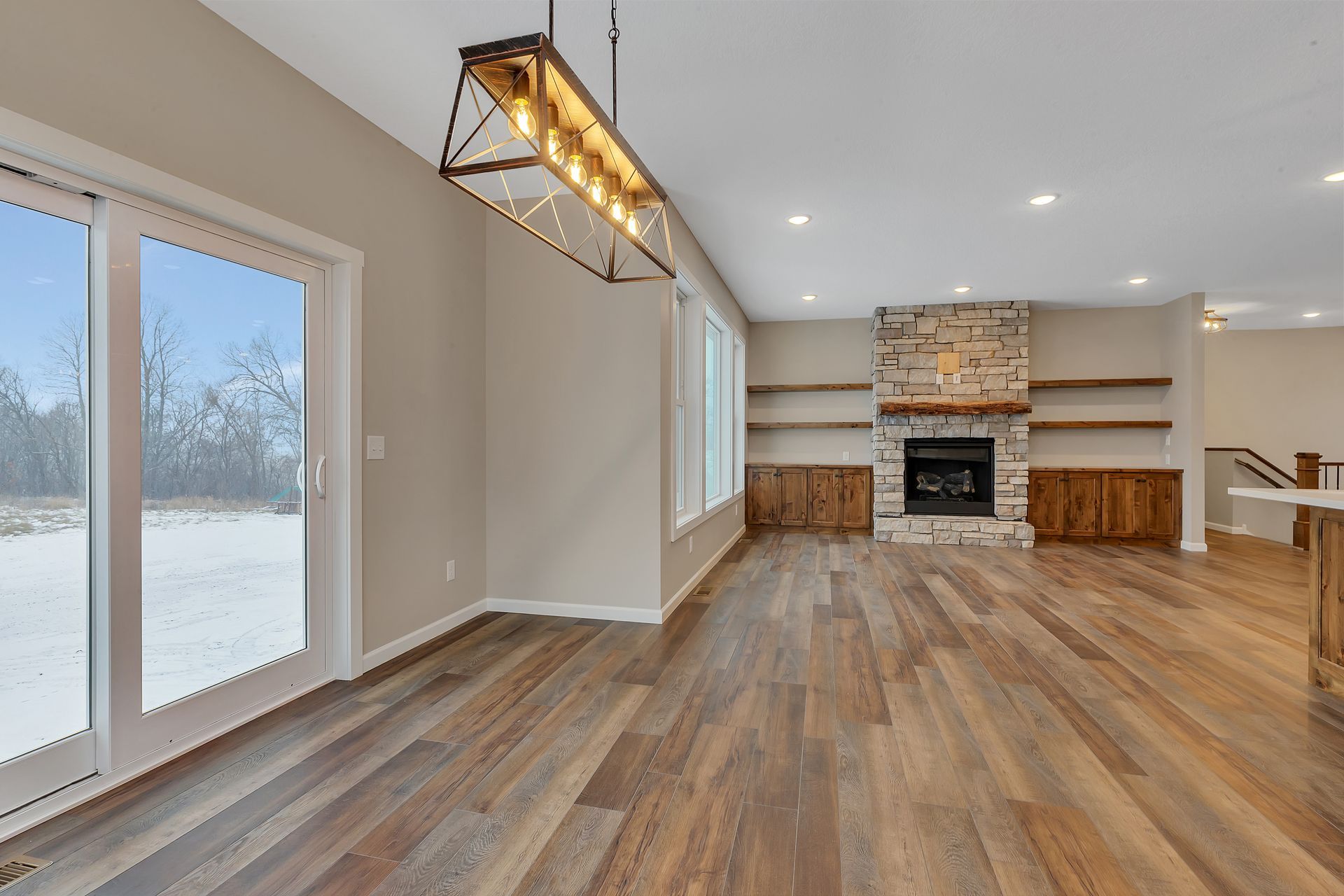 An empty living room with hardwood floors and a fireplace.