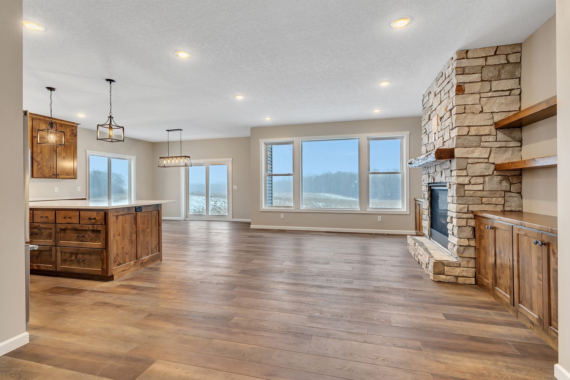 A large empty room with hardwood floors and a fireplace.