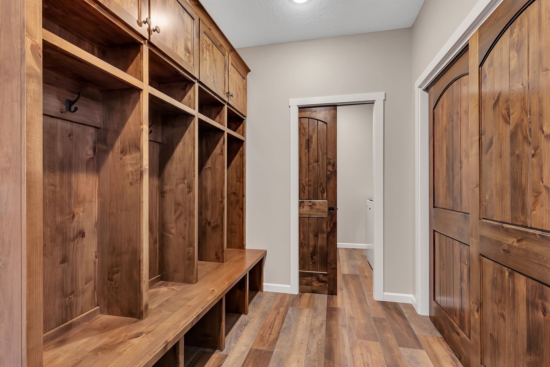 A walk in closet with wooden shelves and a sliding door.