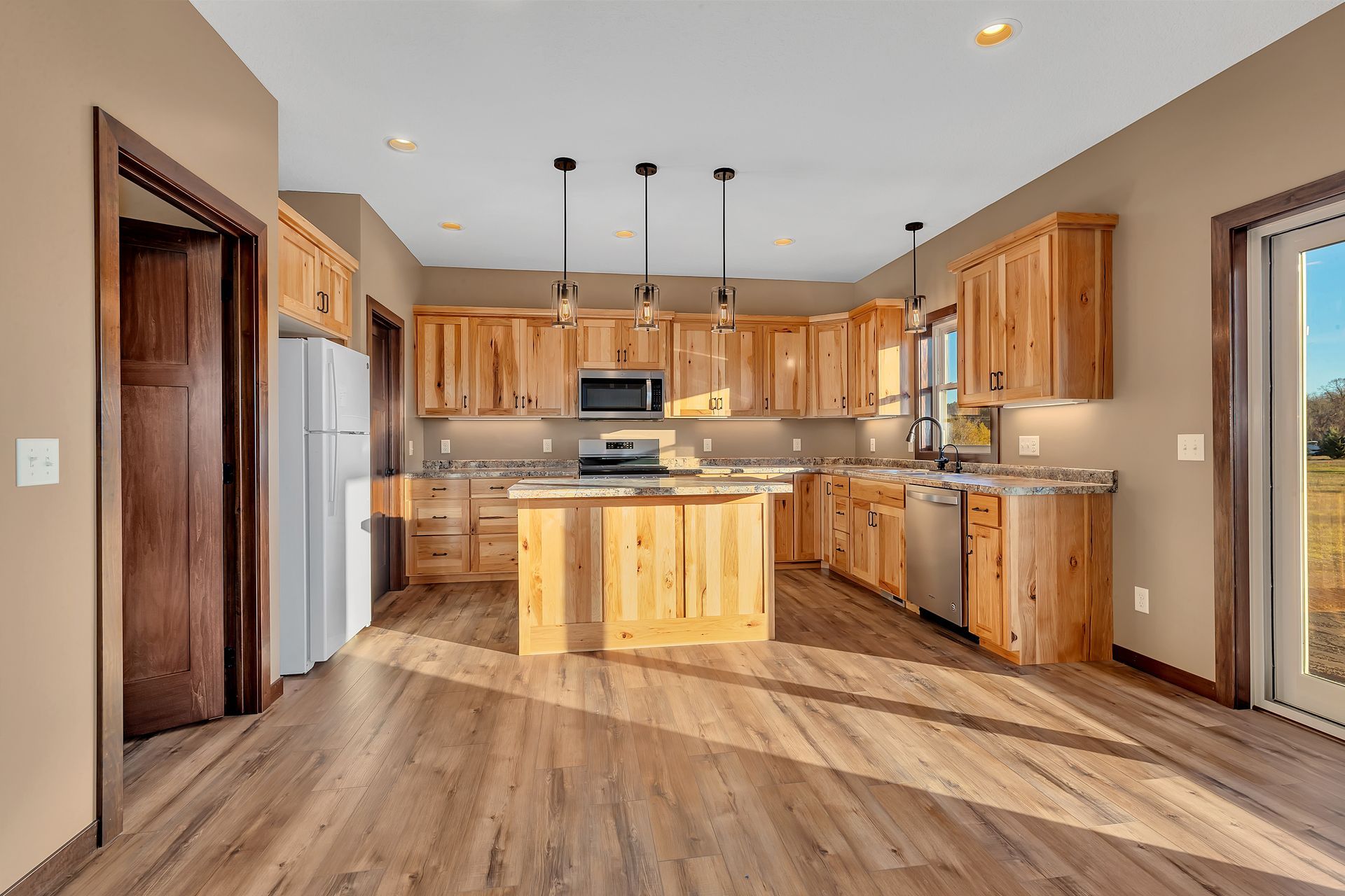 A large kitchen with wooden cabinets , stainless steel appliances , and a large island.